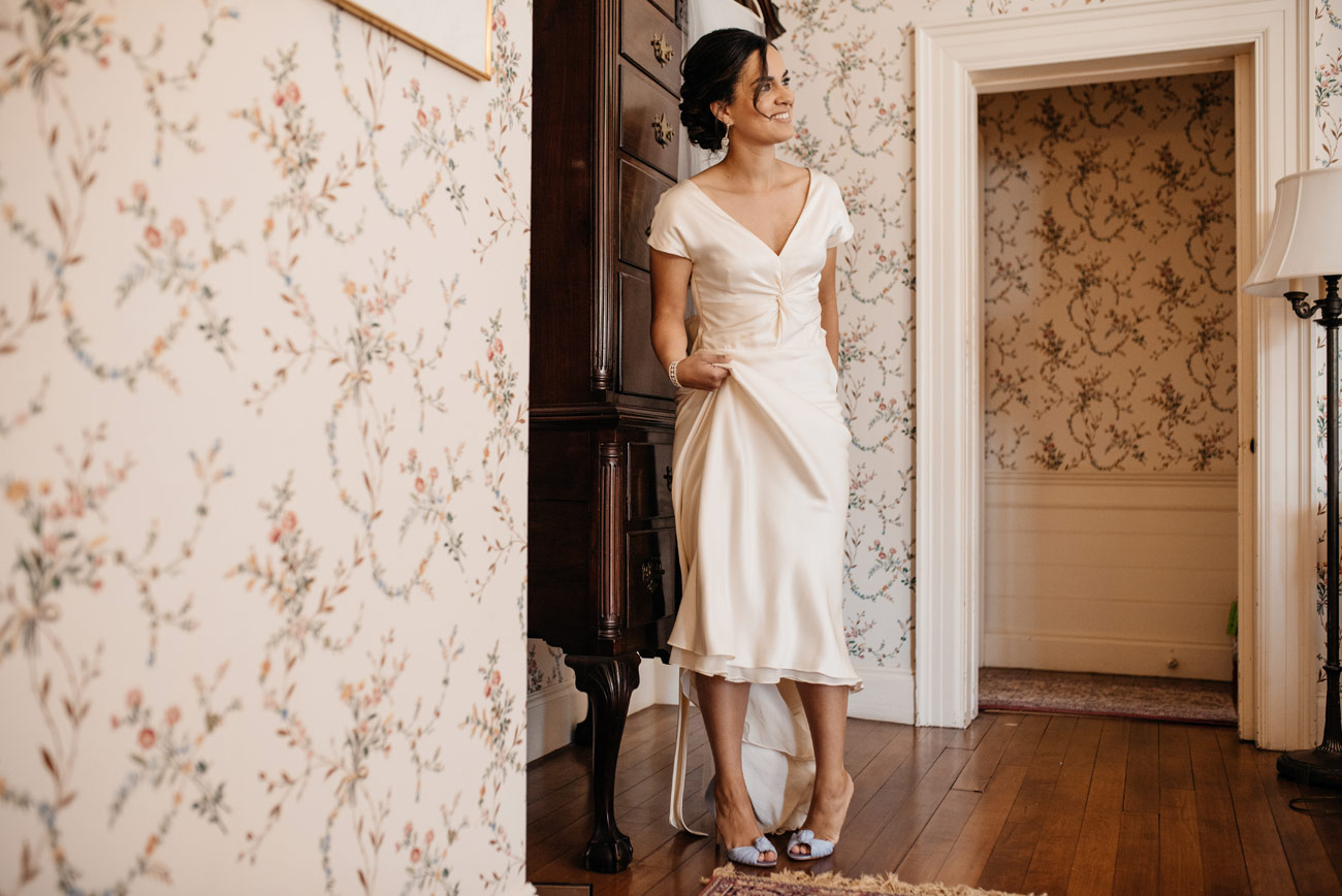 bride putting on shoes at the lyman estate while getting read