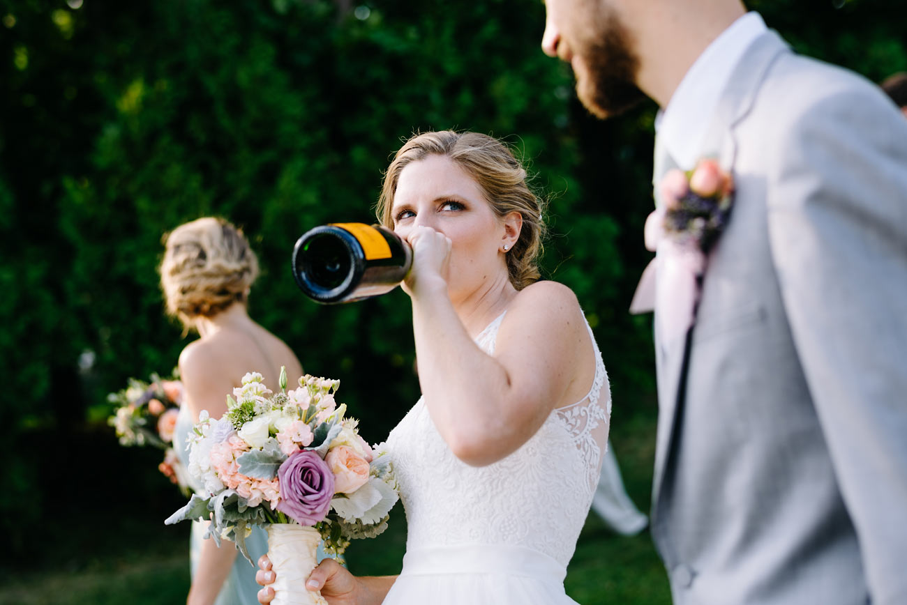 bride chugging champagne at her wediding