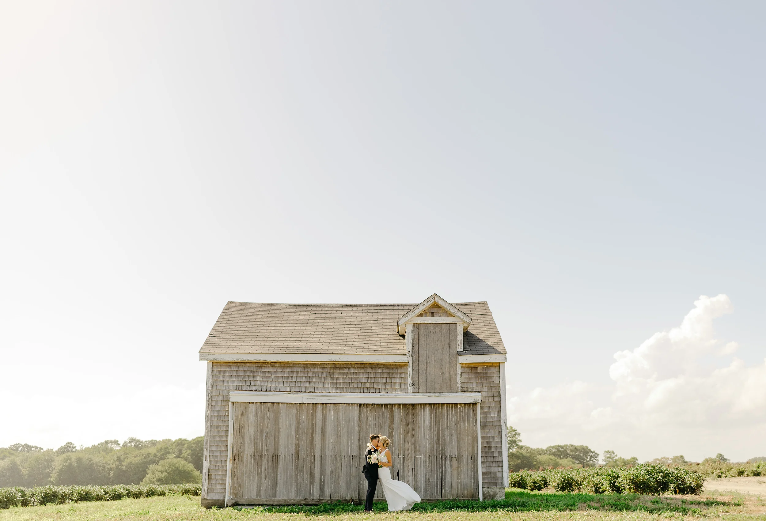  Newport vineyards summer wedding portrait of bride and groom with a barn 