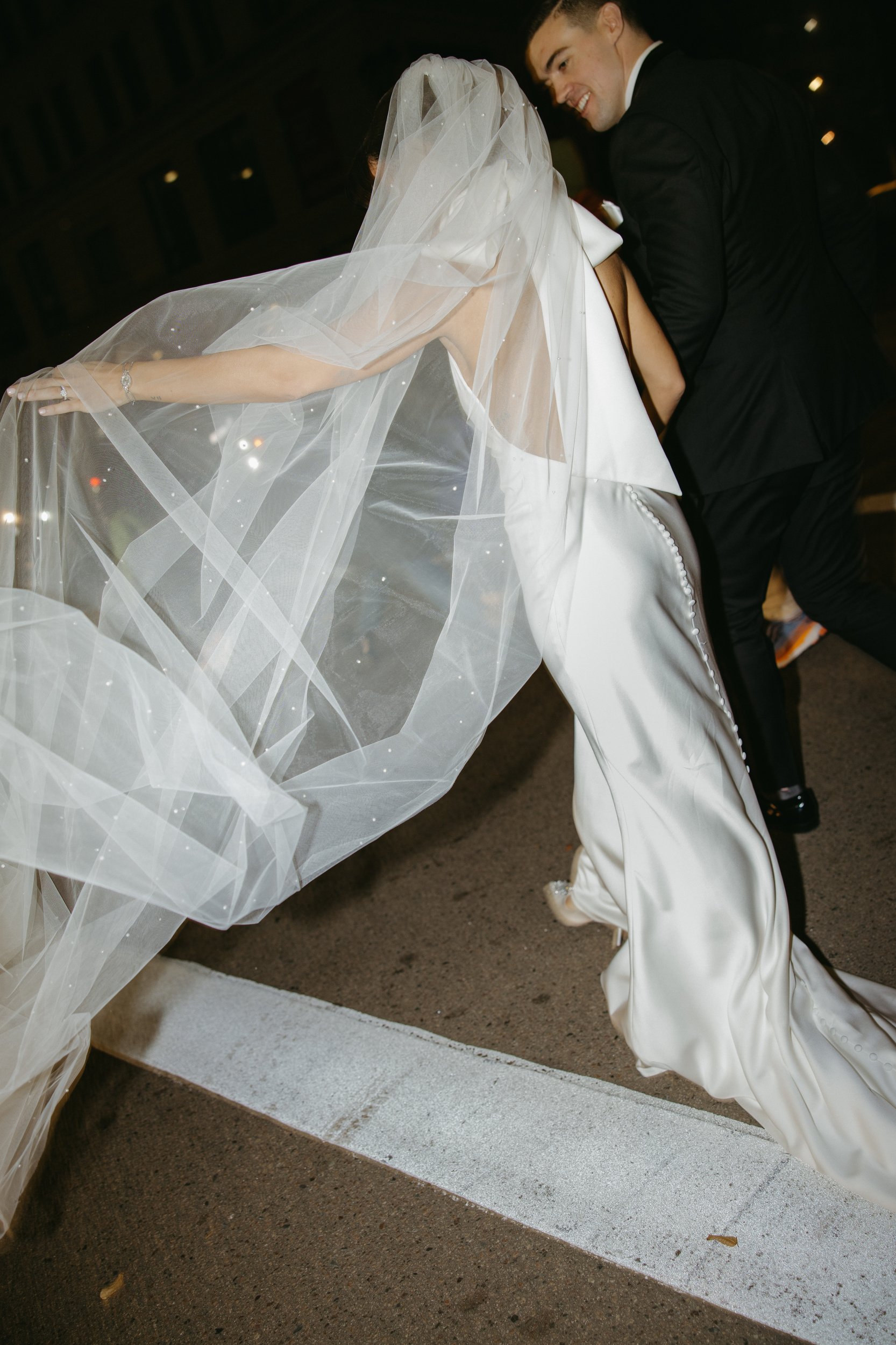 State room documentary style editorial wedding with beautiful couple in downtown Boston black tie wedding with bride with big bow on dress