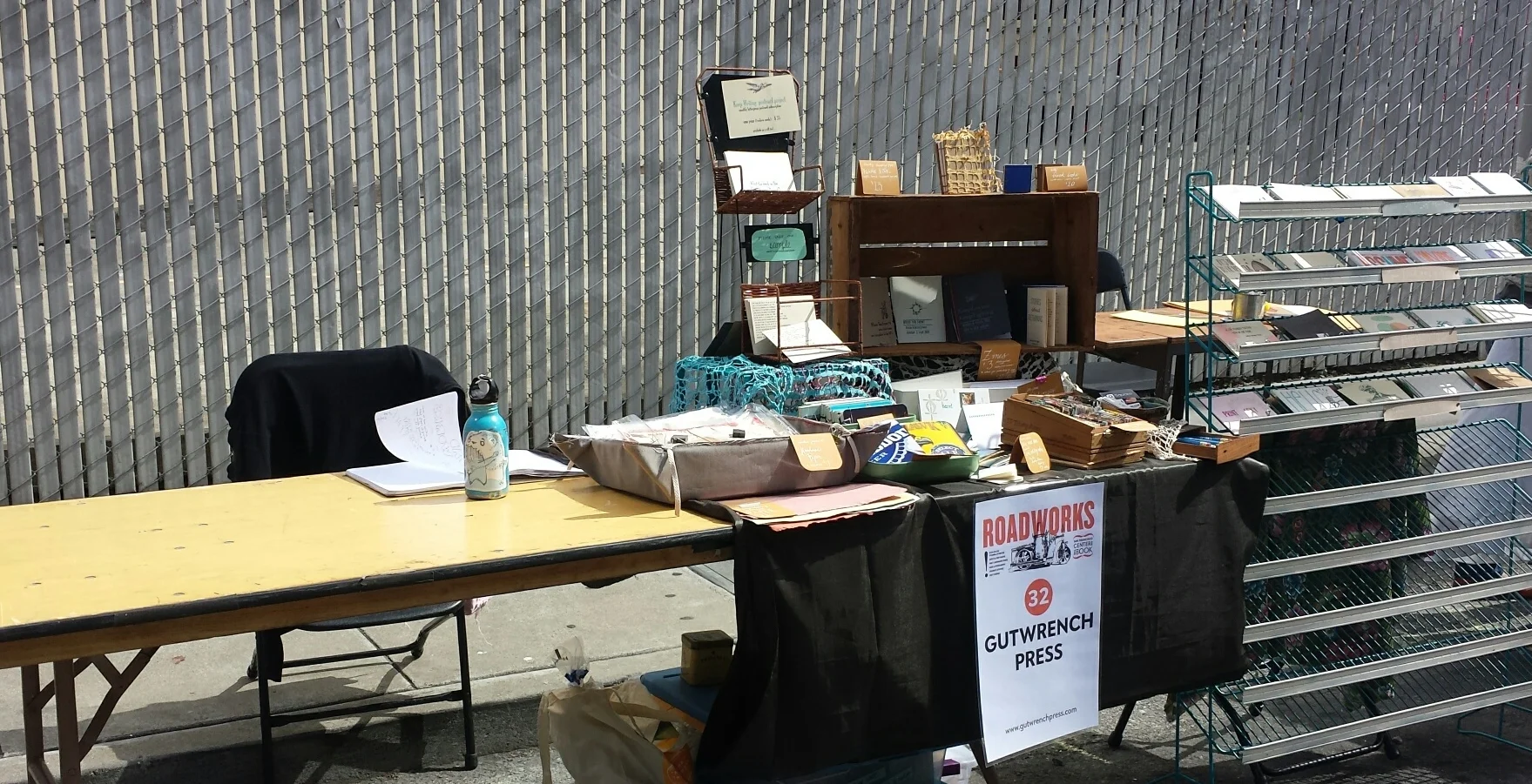 my side of the table and the empty desk area left by my missing tablemate