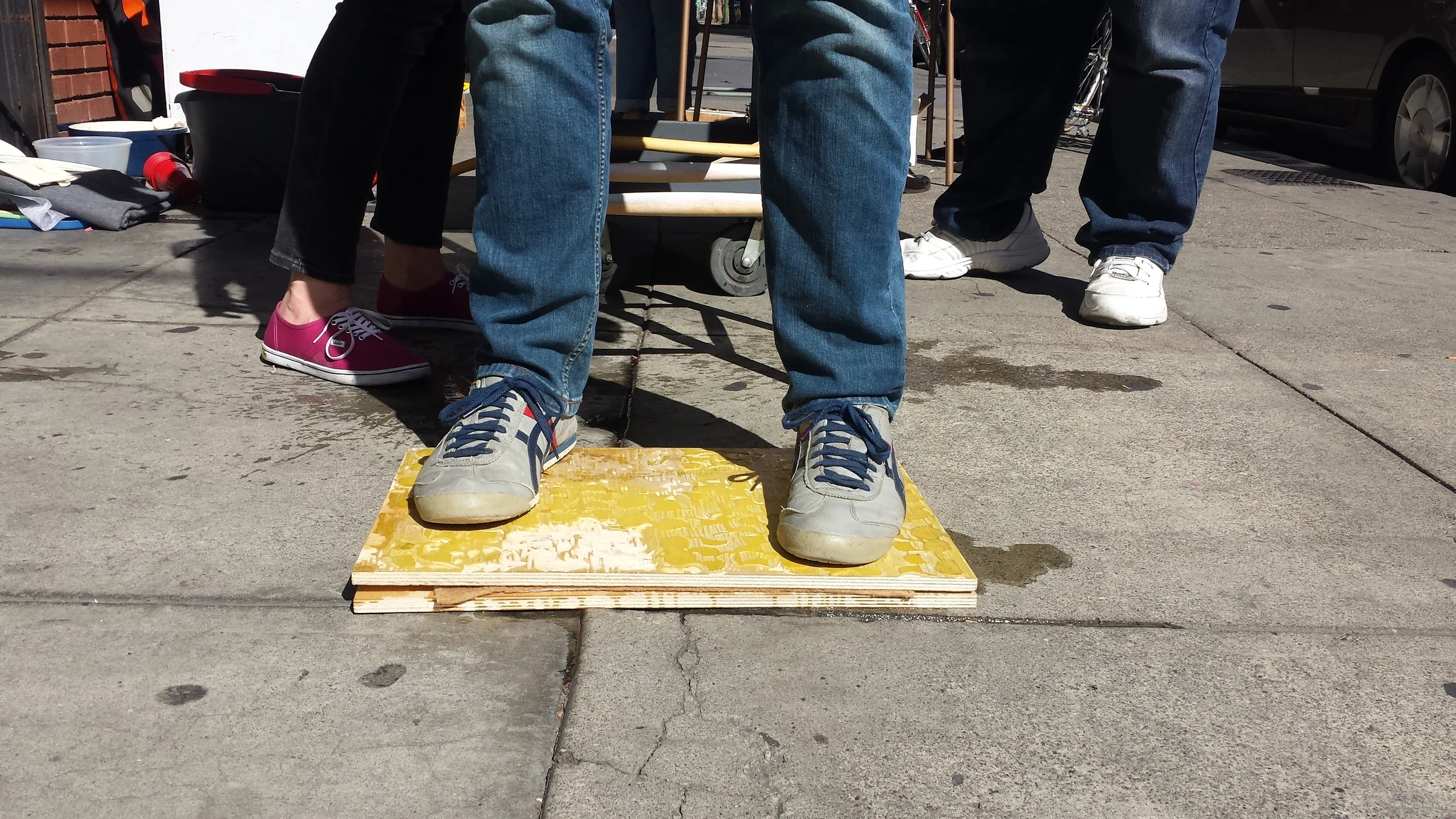 Liam stands on old woodblock carvings re-purposed as boards to press out water in the new sheets. The sheets are between felts between the boards.