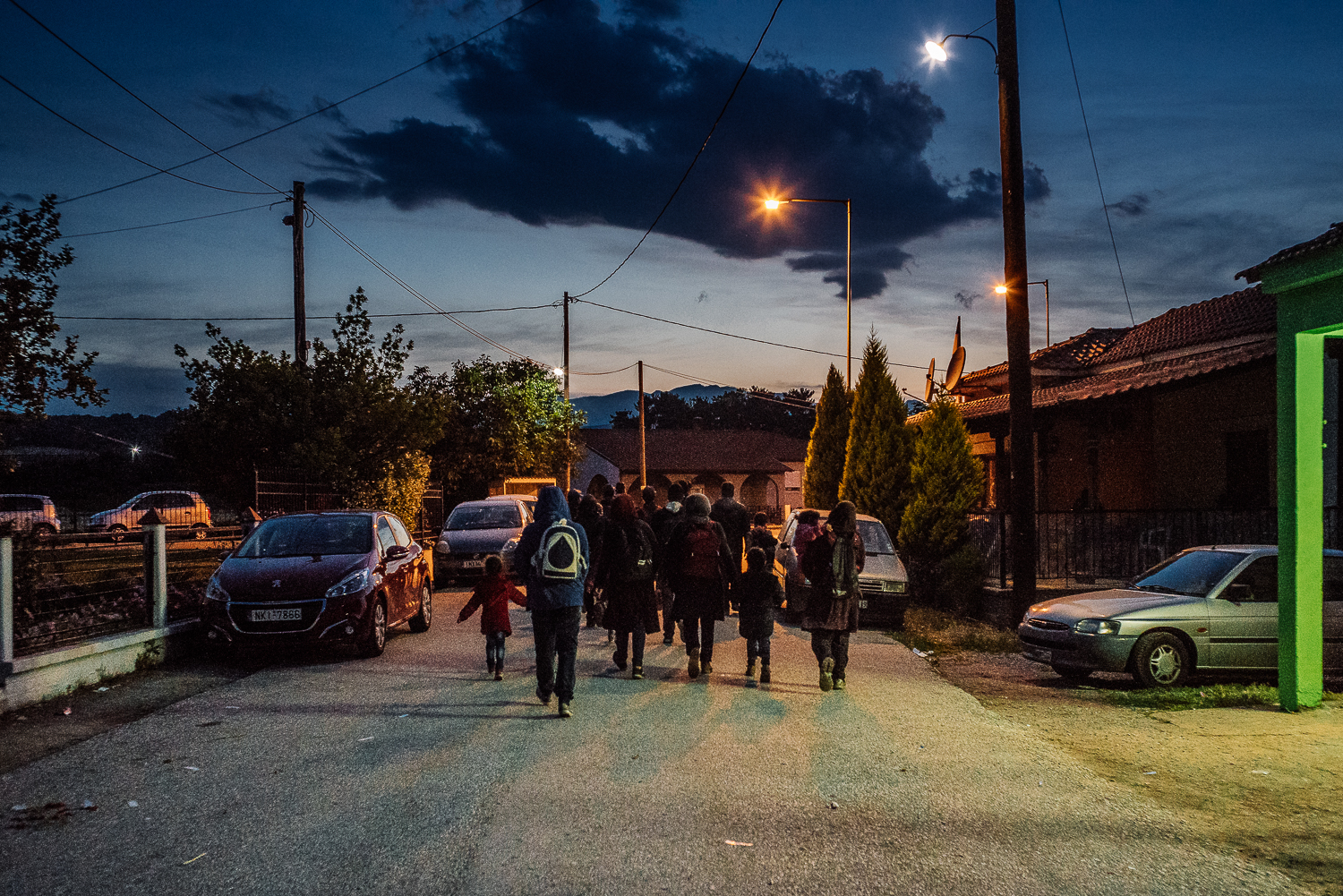  A family of asylum seekers making one last attempt to cross the border into Macedonia in the cover of darkness before being forced to relocate to official camps. Idomeni, Greece, 2016 