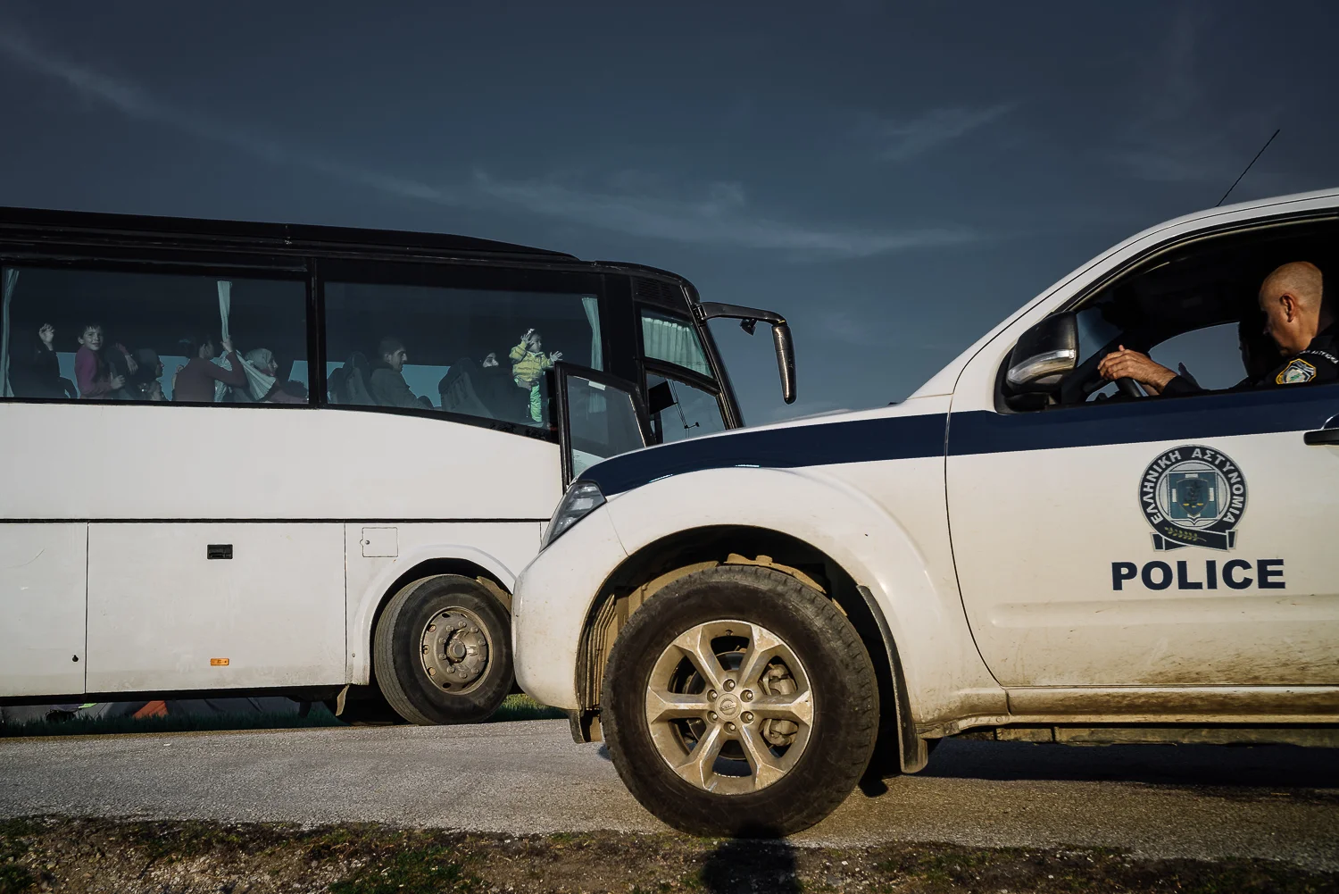 A police escort for a bus of asylum seekers to official camps. Idomeni, Greece, 2016