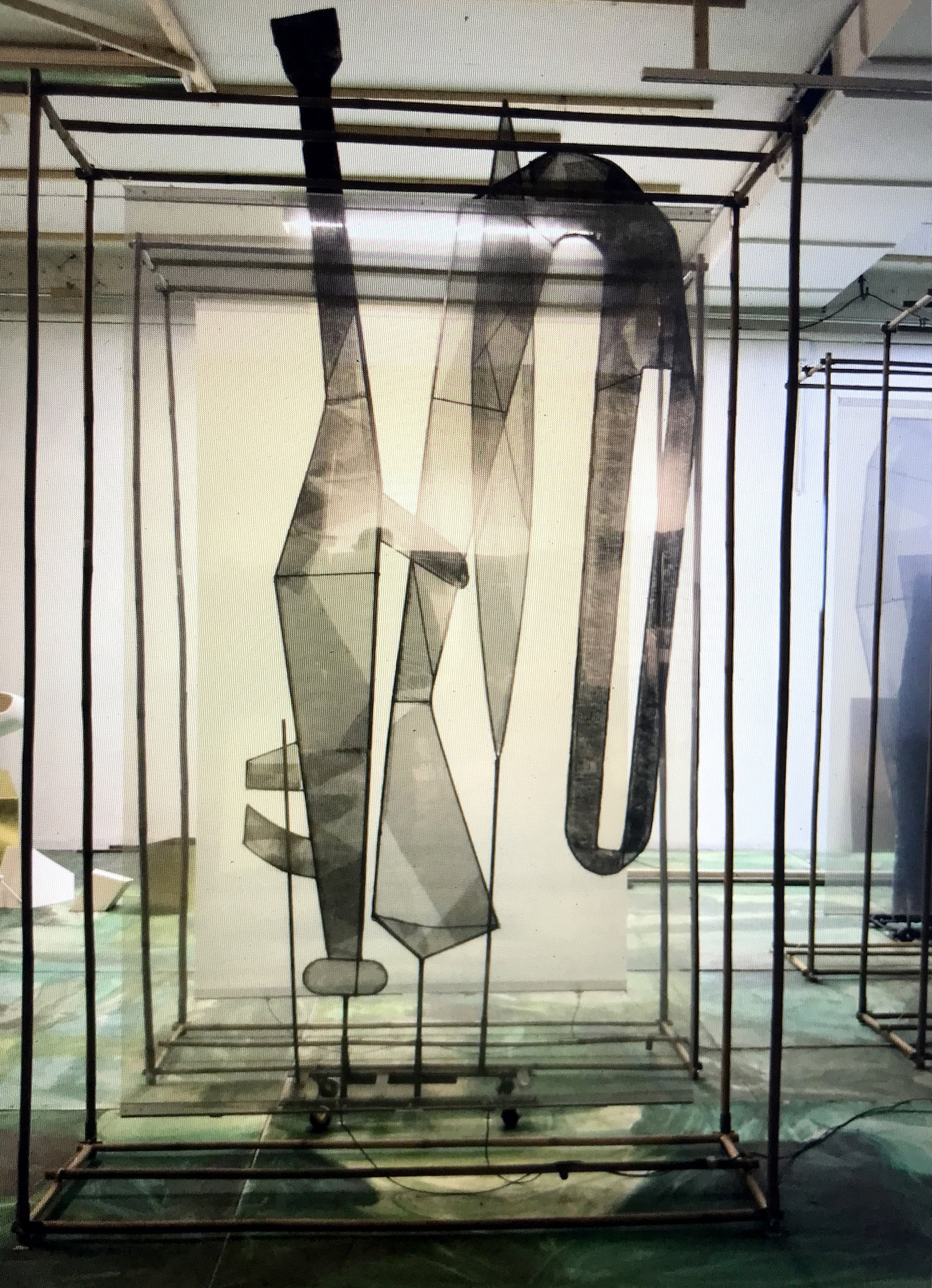 Metal sculpture between screens