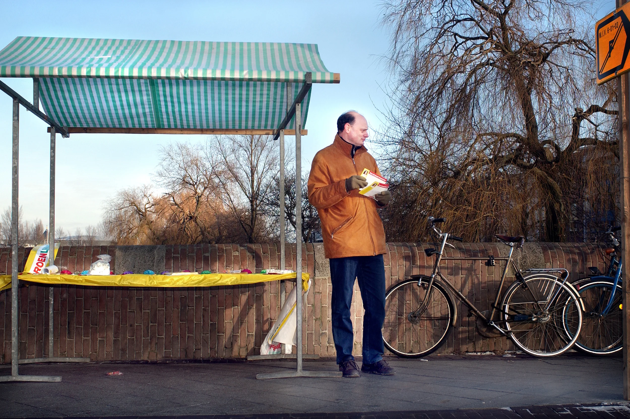 En daar is ie weer. Hij was een tijdje uit de picture, maar Frank Kohler, oud wethouder van Amsterdam, staat op zaterdag middag vol goede moed op de Middenweg folders uit te delen voor Groen Links.