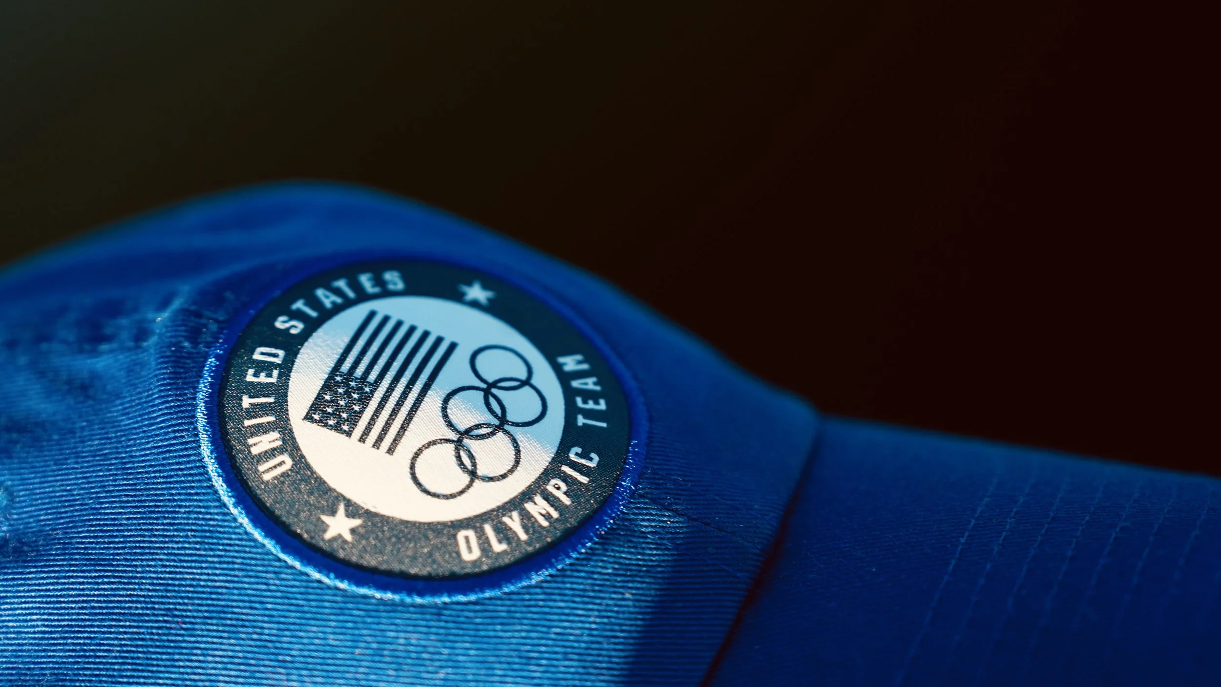 Close-up of a blue Olympic Team USA badge with the Olympic rings and barcode.