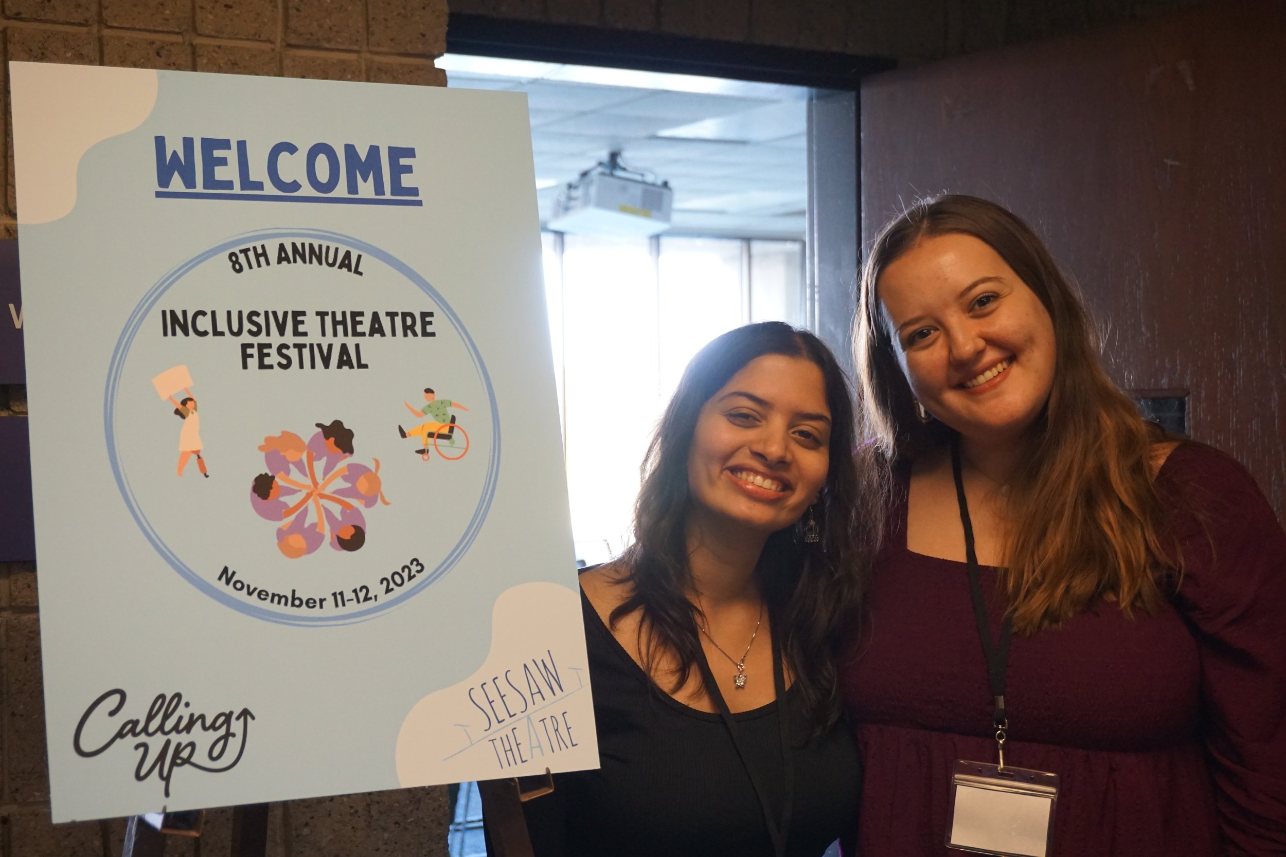 Aashna and Molly standing next to the ITF sign