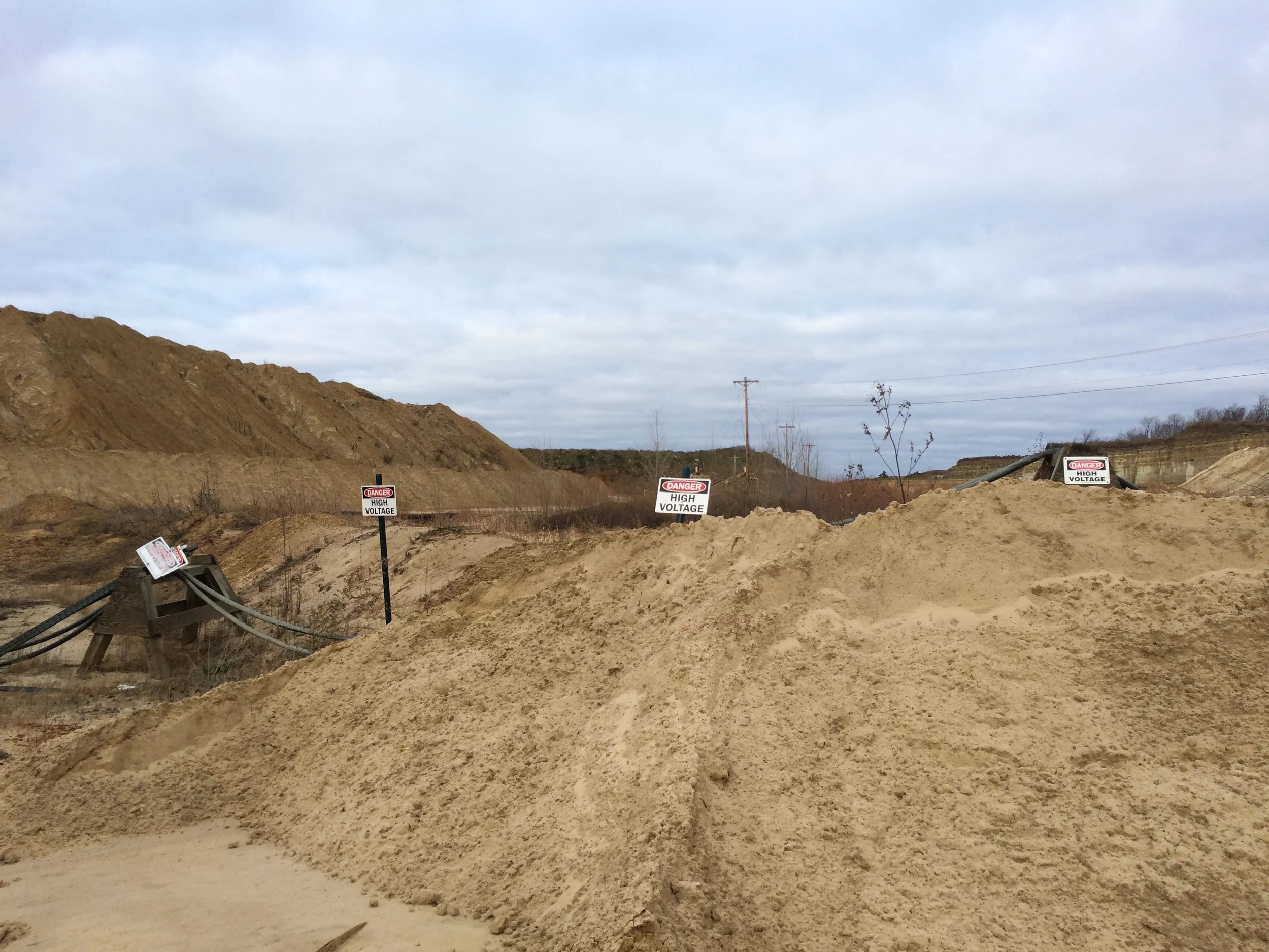 Can't go past here! Not only are there high voltage electric lines running through the area, but it was an active blasting (TNT) zone. They use the TNT to shake new sand loose from the earth.