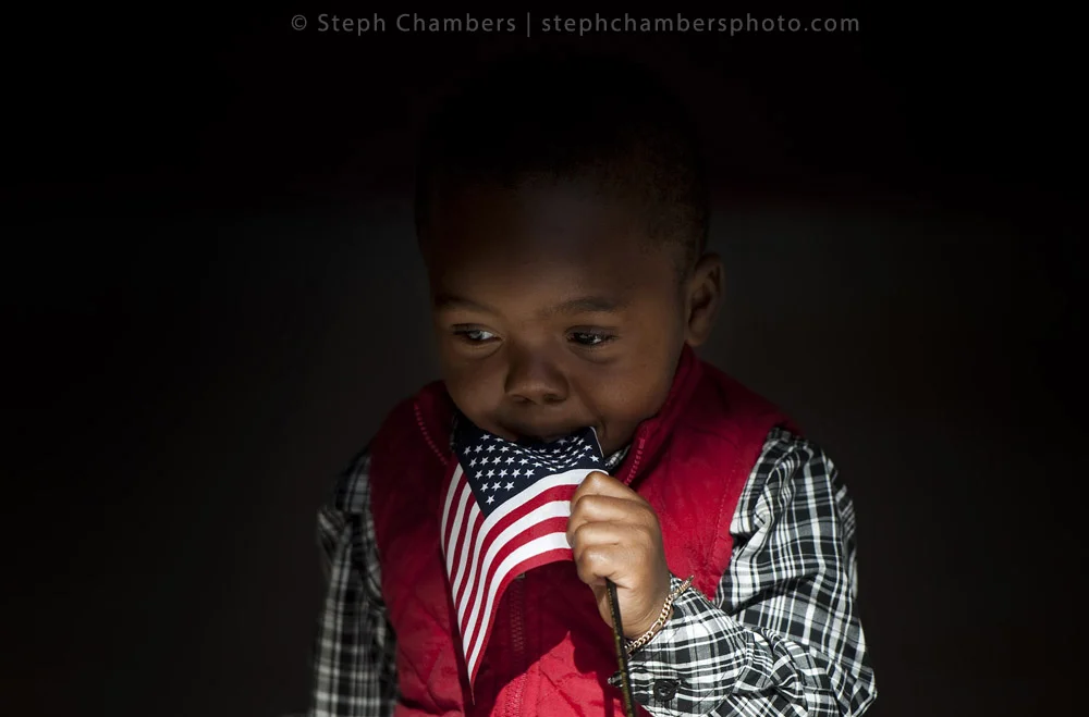 Eryn Doerue, 2, of Liberia uses a flag as a pacifier after a naturalization ceremony on Friday, Oct. 23, 2015 at Indiana University of Pennsylvania's Kovalchick Convention Center-Toretti Auditorium. The ceremony granted citizenship for 101 candidate…