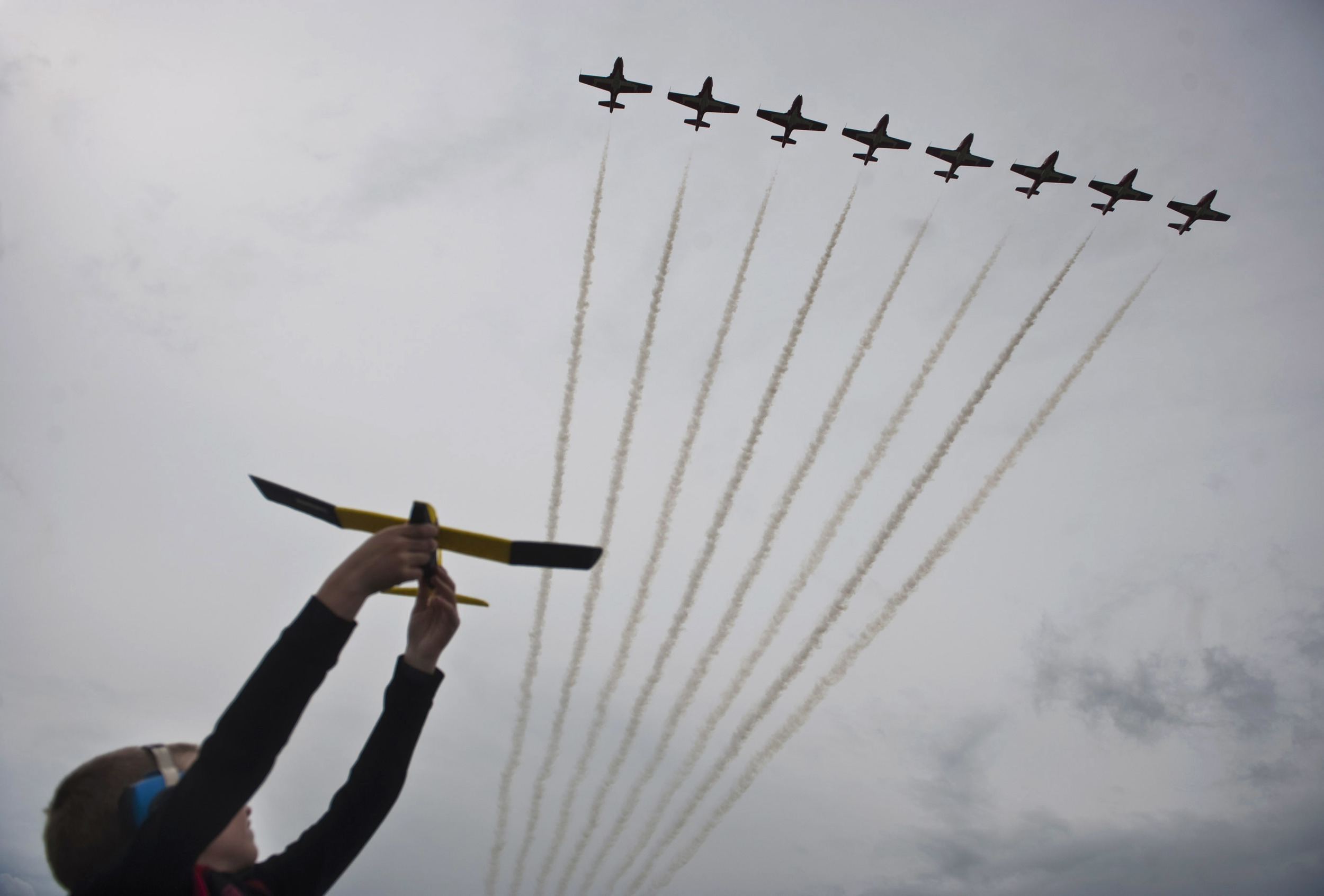 Lawson Miller, 6, of Canonsburg flies his toy airplane as the Canadian Forces Snowbirds pass overhead during the second day of the Shop ’n Save Westmoreland County International Air Show at Arnold Palmer Regional Airport in Unity Township on Sunday, May 22, 2016.