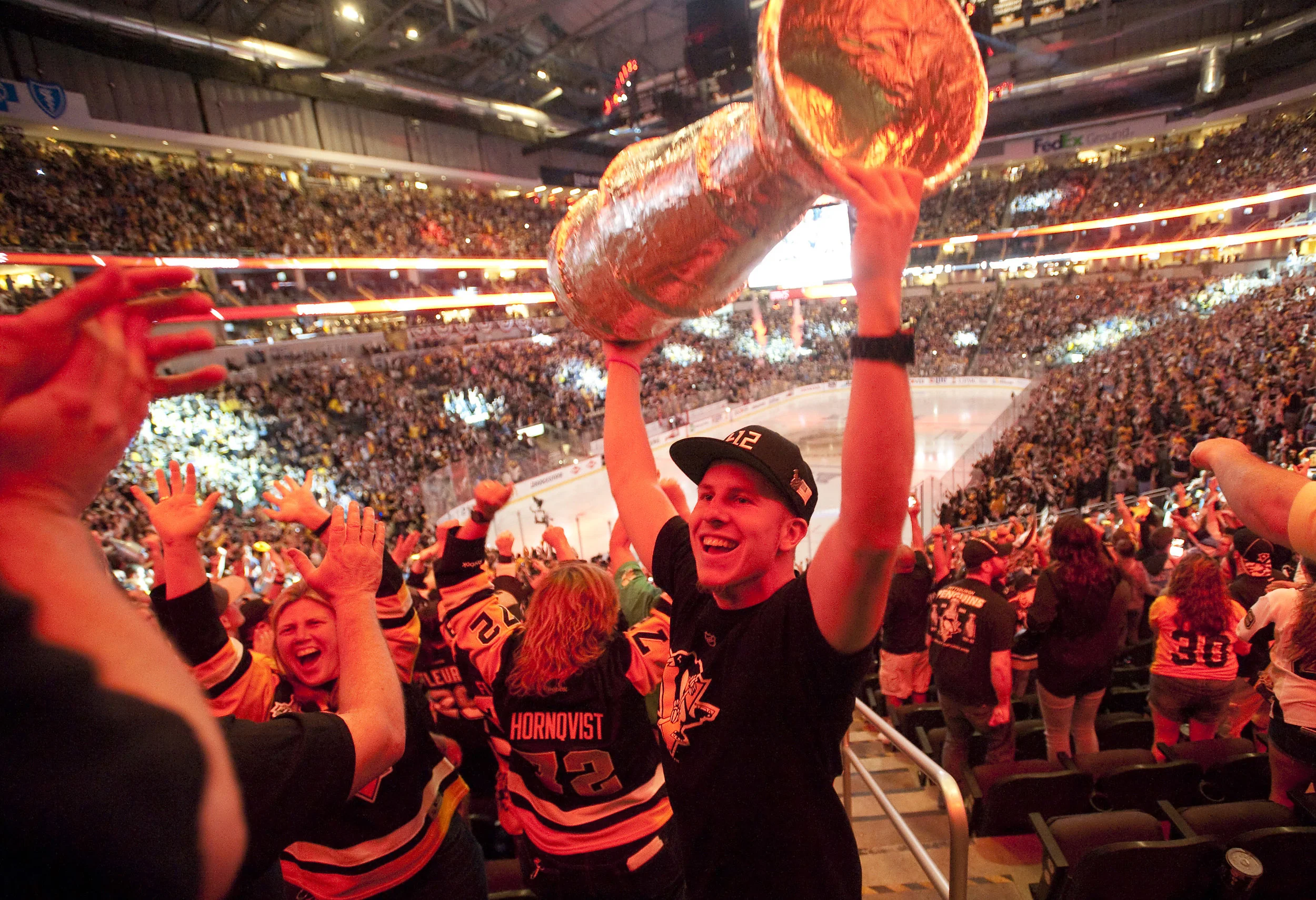 Red light from the final buzzer illuminates Mike Cummings of Overbrook as he hoists his homemade Stanley Cup during the Stanley Cup Finals, between the Pittsburgh Penguins and the San Jose Sharks, Game 6 indoor watch party at Consol Energy Center on Sunday, June 12, 2016.