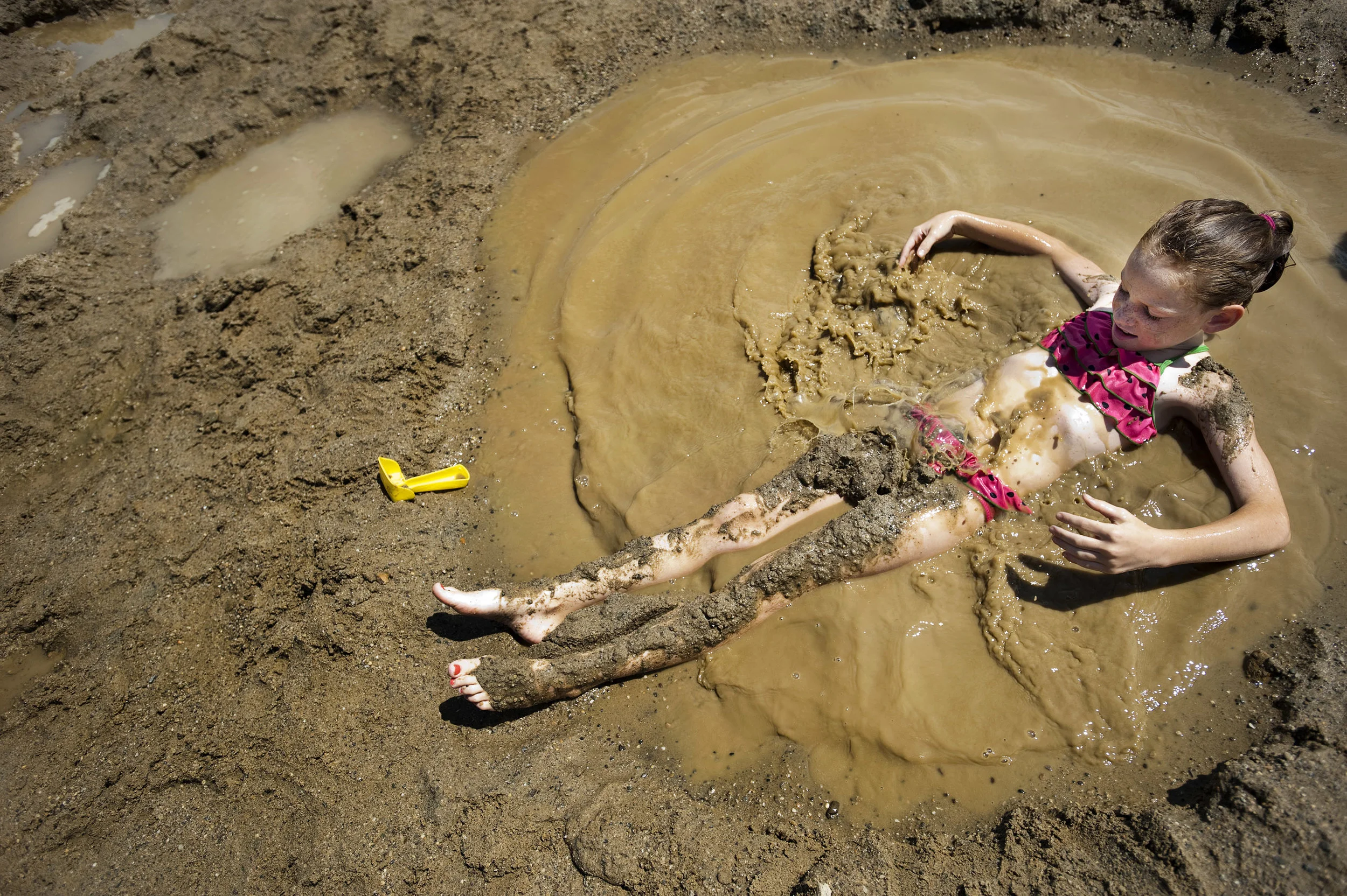 Charli White, 9 of Latrobe, splashes in a puddle she made at while swimming at Keystone State Park near Derry Township on Tuesday, July 26, 2016. "I'm the mud watermelon queen!" White said while sporting her watermelon swimsuit.