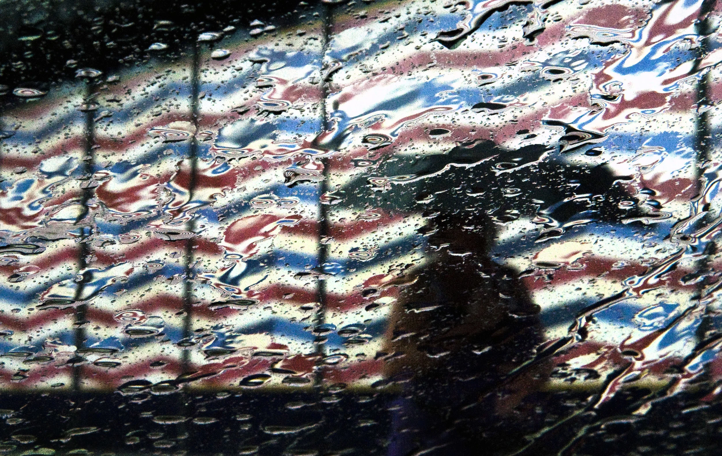 Rain falls around a pedestrian as she shields herself with an umbrella while making her way along Clay Avenue in Jeannette on Wednesday, Aug. 17, 2016.