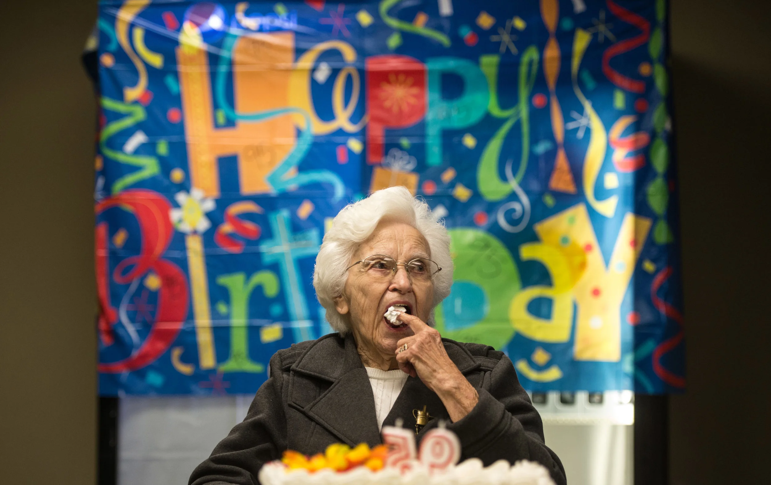 Genevieve Johnson, the longtime librarian at Seton Hill University, sneaks some icing before blowing out her candles during her 95th birthday party on Friday, Sept. 30, 2016 at Mt. Odin Golf Course in Greensburg.