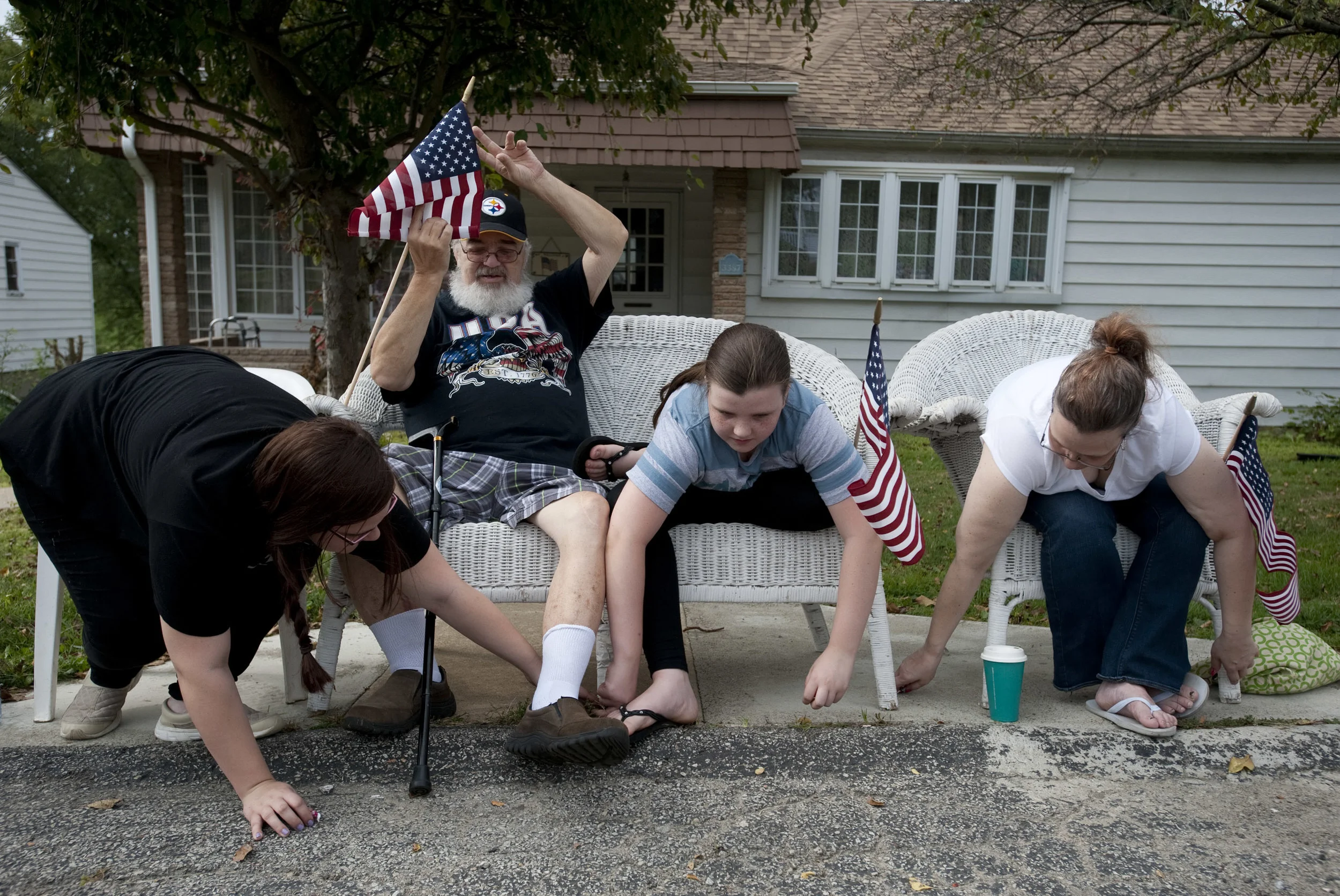 Eddie Miller leans back as his granddaughter Alexis Nadell (left), granddaughter Hayley Nadell (center) and daughter Heather Nadell gather candy from a parade float during the Penn Township Fall Festival on Saturday, Sept. 17, 2016 at the Penn Towns…