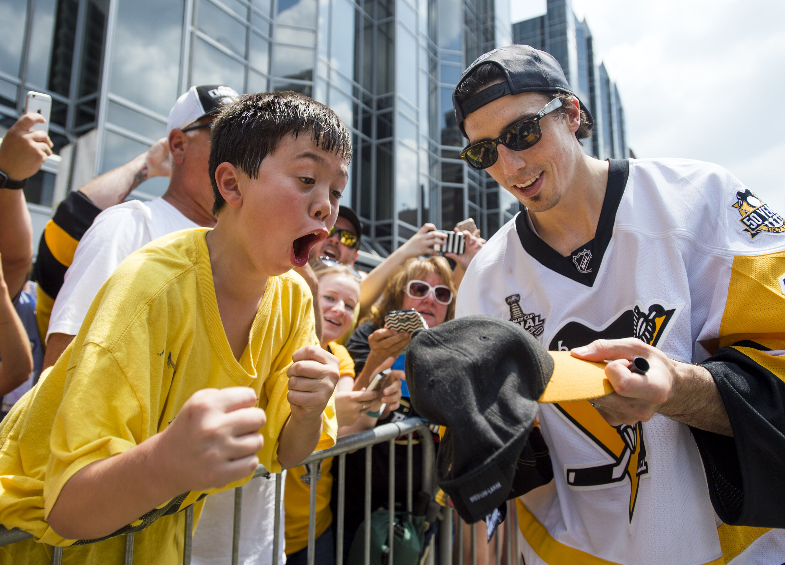  Pittsburgh Penguin Marc-Andre Fleury signs a hat for a young fan during the Pittsburgh Penguins victory parade on Wednesday, June 14, 2017 at Grant Street and Boulevard of the Allies.  