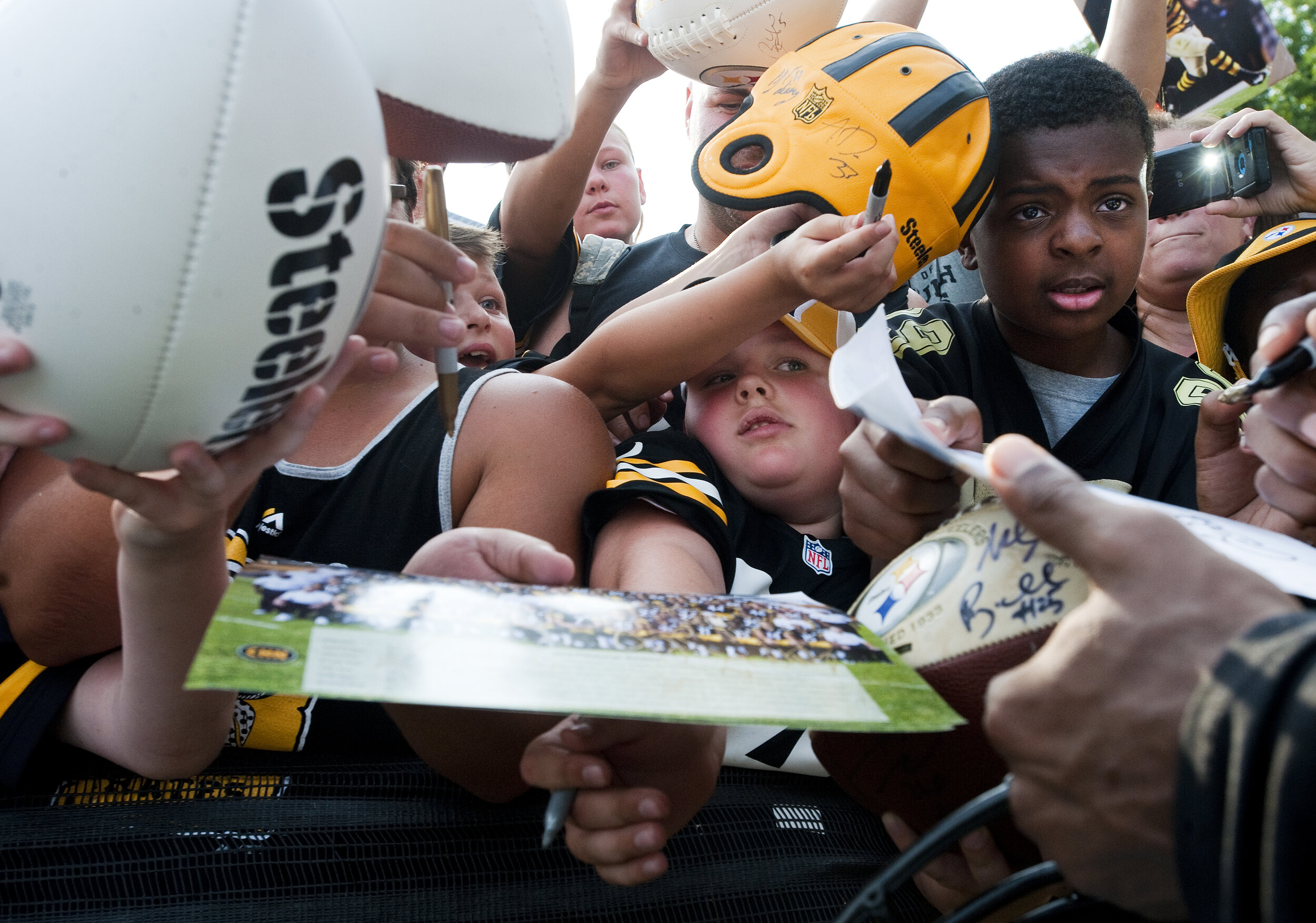  A young fan is sandwiched between others while waiting for Le'Veon Bell to sign autographs during the first day of Pittsburgh Steelers training camp on Sunday, July 26, 2015 at St. Vincent College in Unity. 