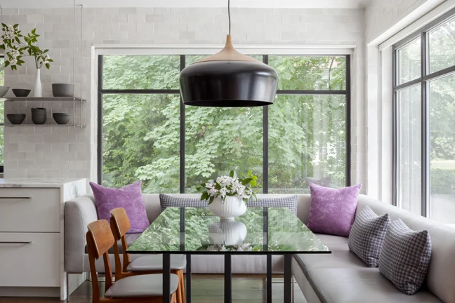 A once dark and gloomy eating area is now full of light, letting in nature. It's a step away from the family's outdoor terrace and pool area.