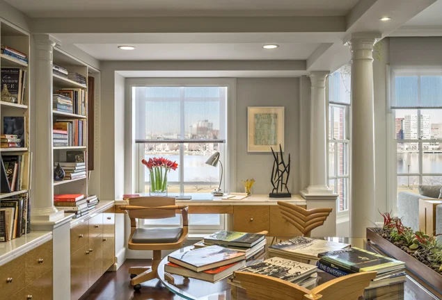 KR+H made these cabinets and bookshelves some 25 years ago. To the right is a large family area with a soaring ceiling. You can glimpse the remarkable view of the Charles River.