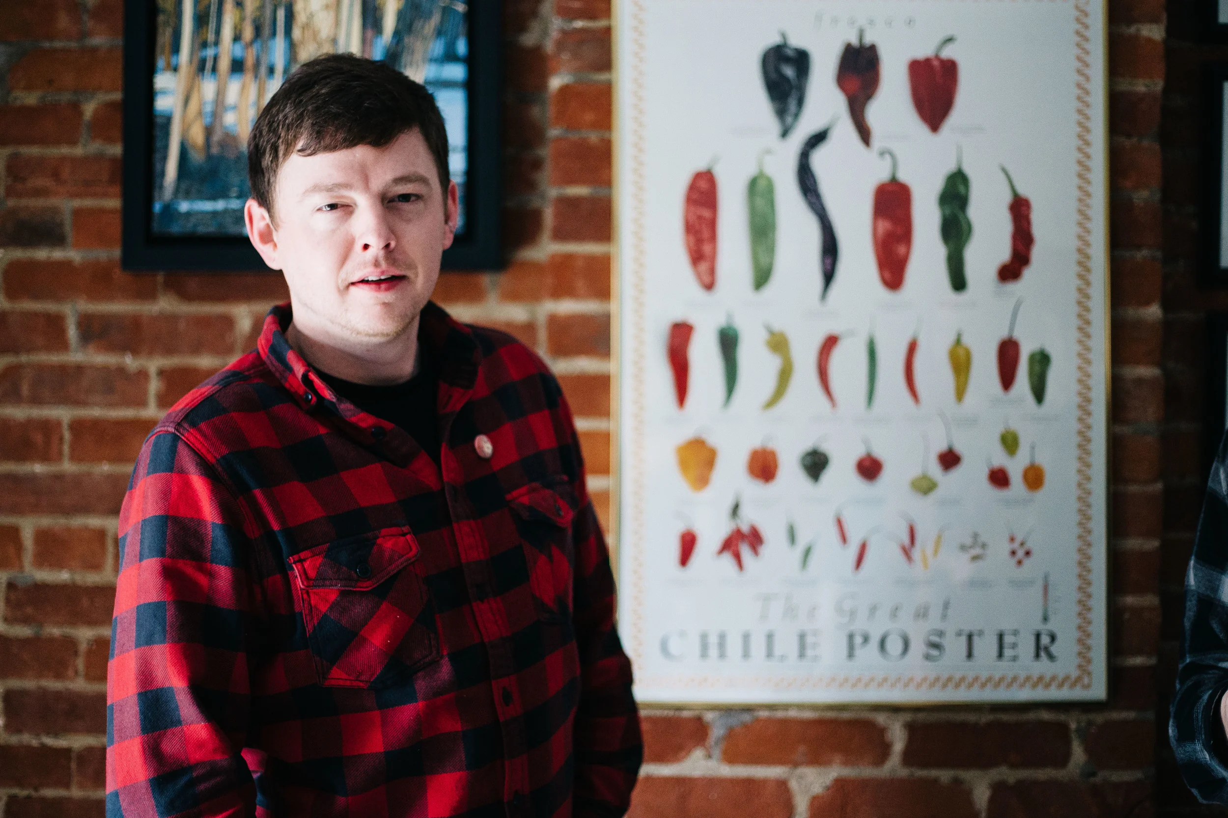 Jeff Russell, also known as Pepper, stands in front of a chile pepper poster at the Sladkowski home in Toronto, Ontario, Thursday April 7, 2016. The nickname Pepper began as a joke but as tour went on, everyone would occasionally be called Pepper. Ex: " You did a good job there, Pepper. Have this beer."