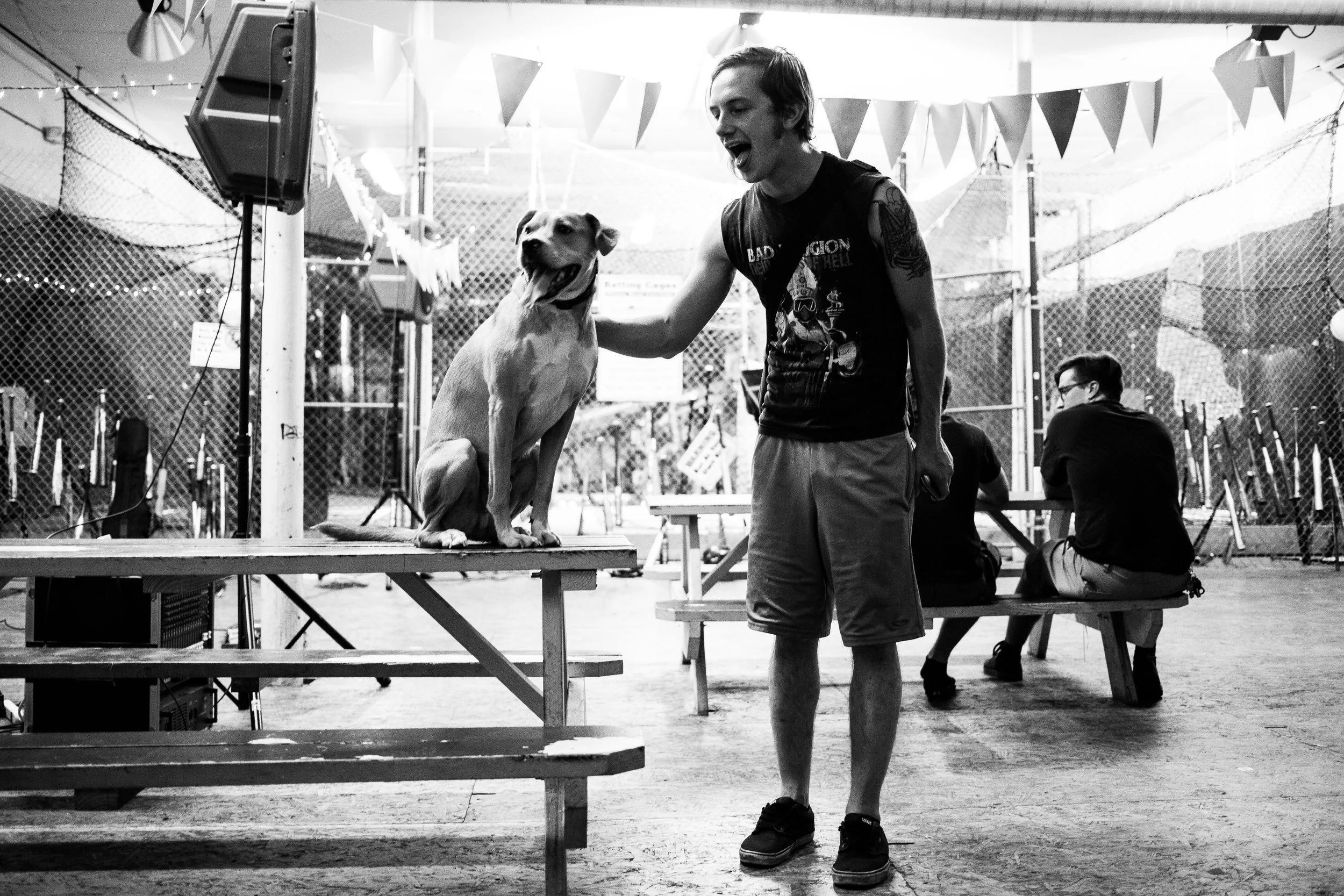 Josh stands with a dog in the venue. 