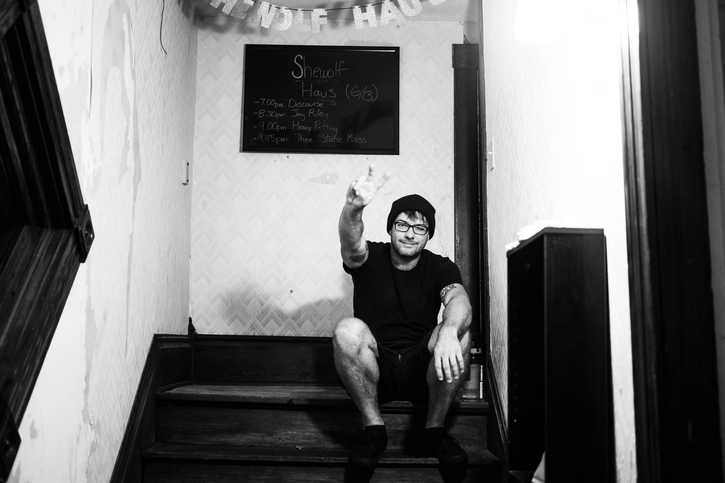 Ryan sitting on the steps inside the Shewolf Haus before the show in Athens, Ohio. Side note: Notice Heavy Petting on the board in the background. Yeah!