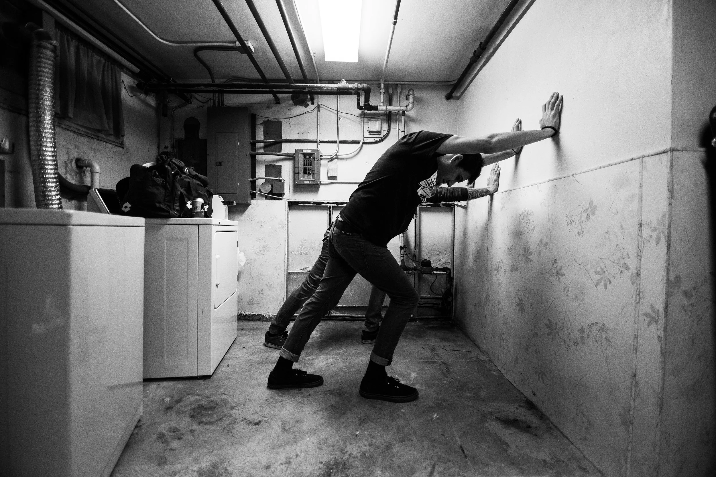Max and Steve stretch in the laundry room/merch room in Madison, Wisconsin.
