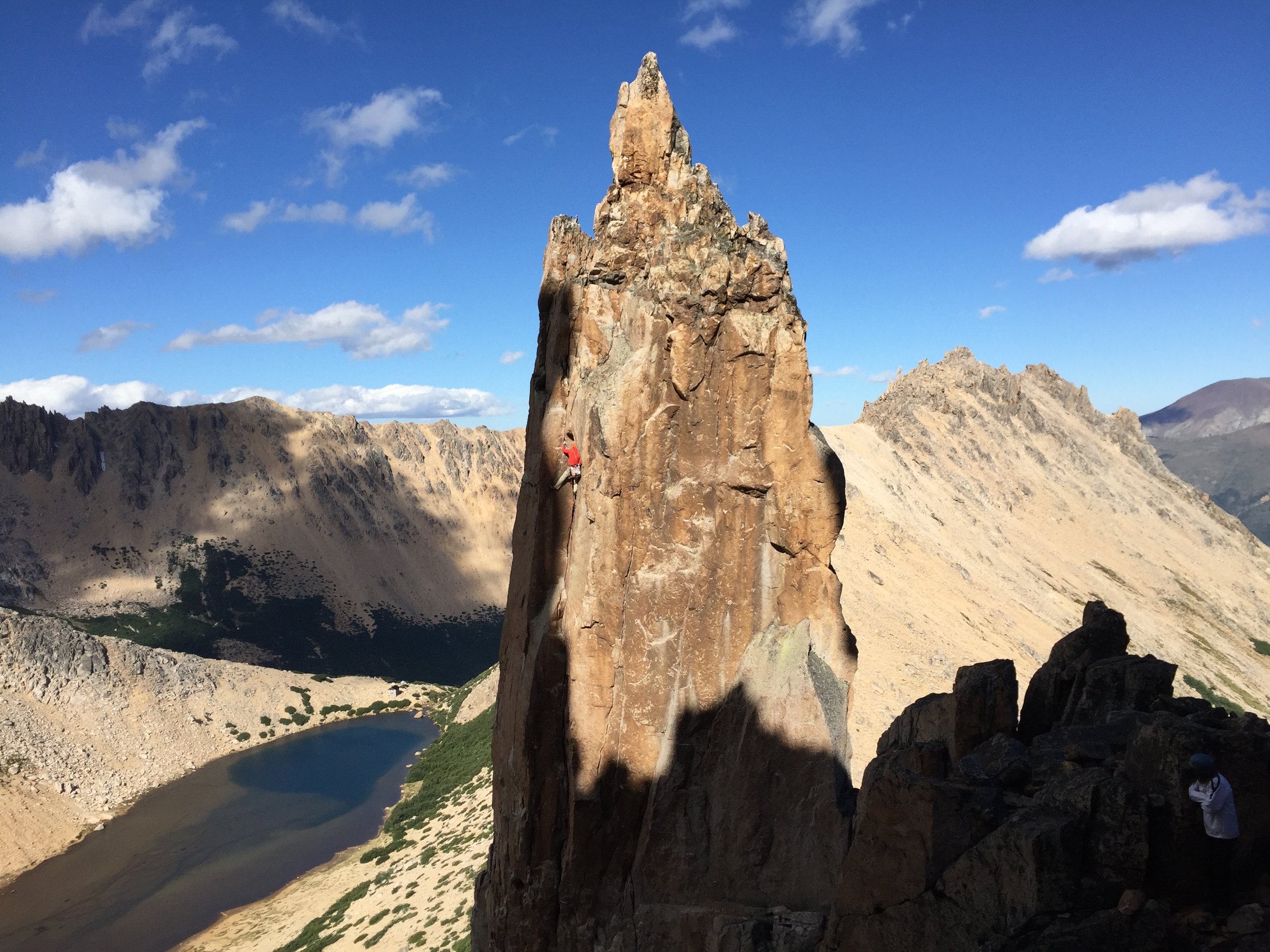 Karah on Del Diedro (5.9) with Laguna Toncek and a tiny Refugio Frey in the background