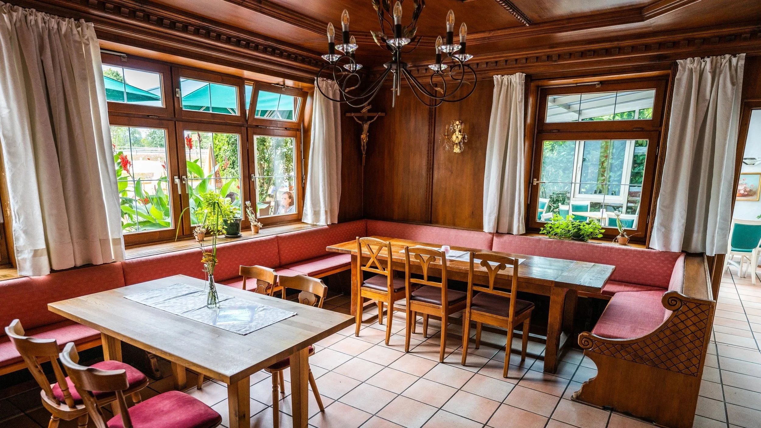 holzvertäfeltes Gastzimmer mit roten Polstern
