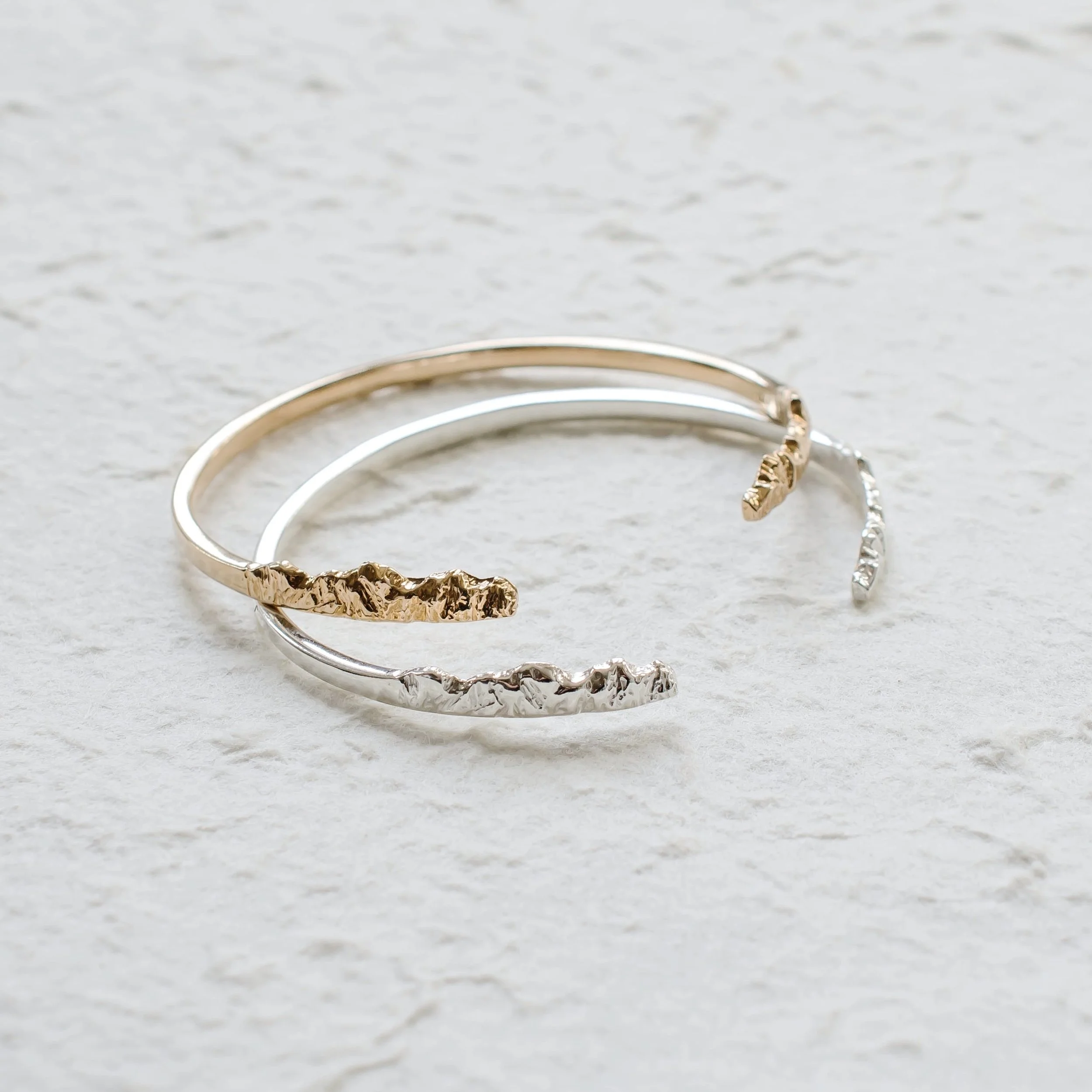 A sleek mountain bracelet cuff that ends with textured peaks and valleys. Wear it as a reminder to enjoy every step of your journey. View our mountain jewelry at www.everlijewelry.com/mountains