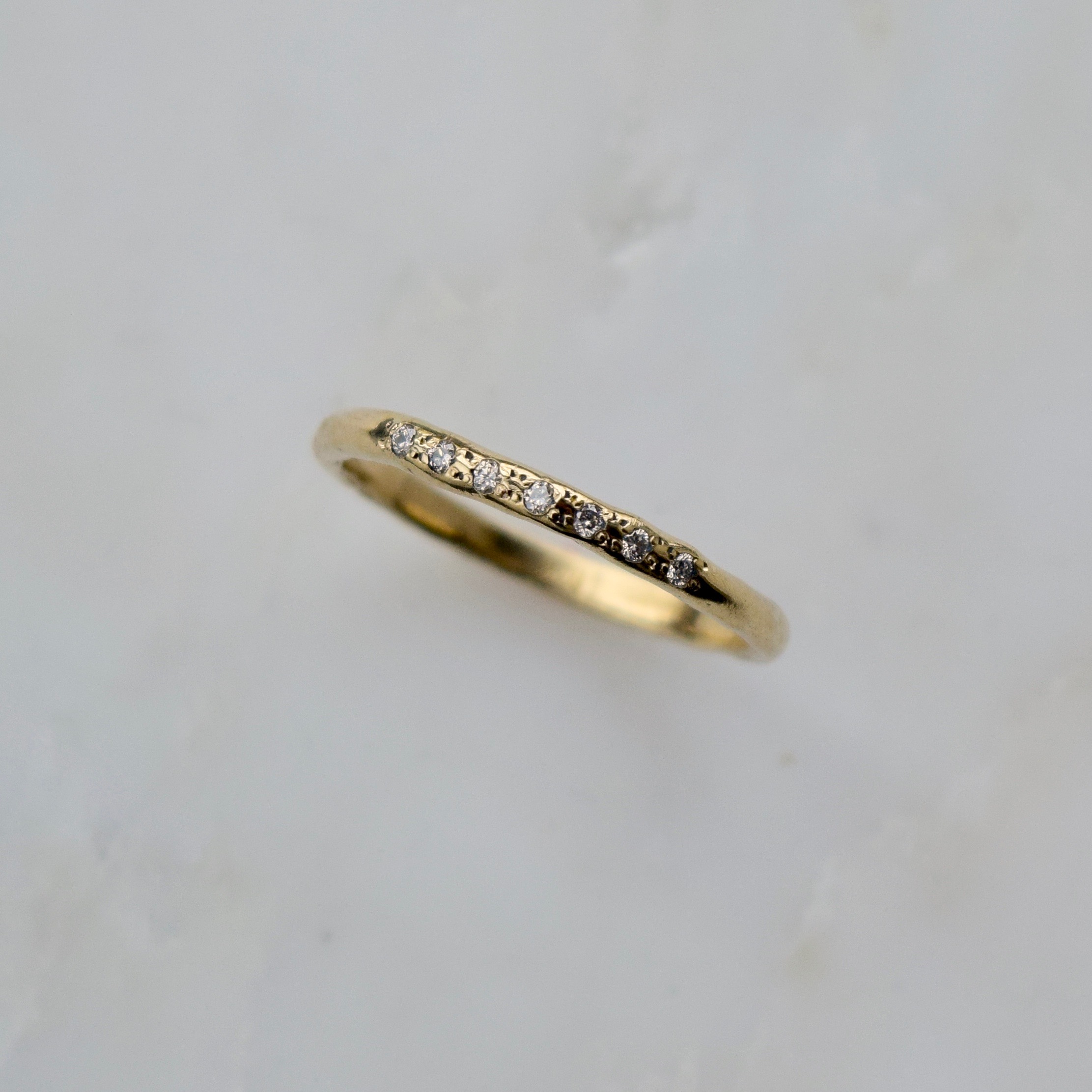 An organically rendered gold diamond band, imprinted with the texture of water ripples. Wear it as a reminder to go with the flow and embrace new destinations ahead.