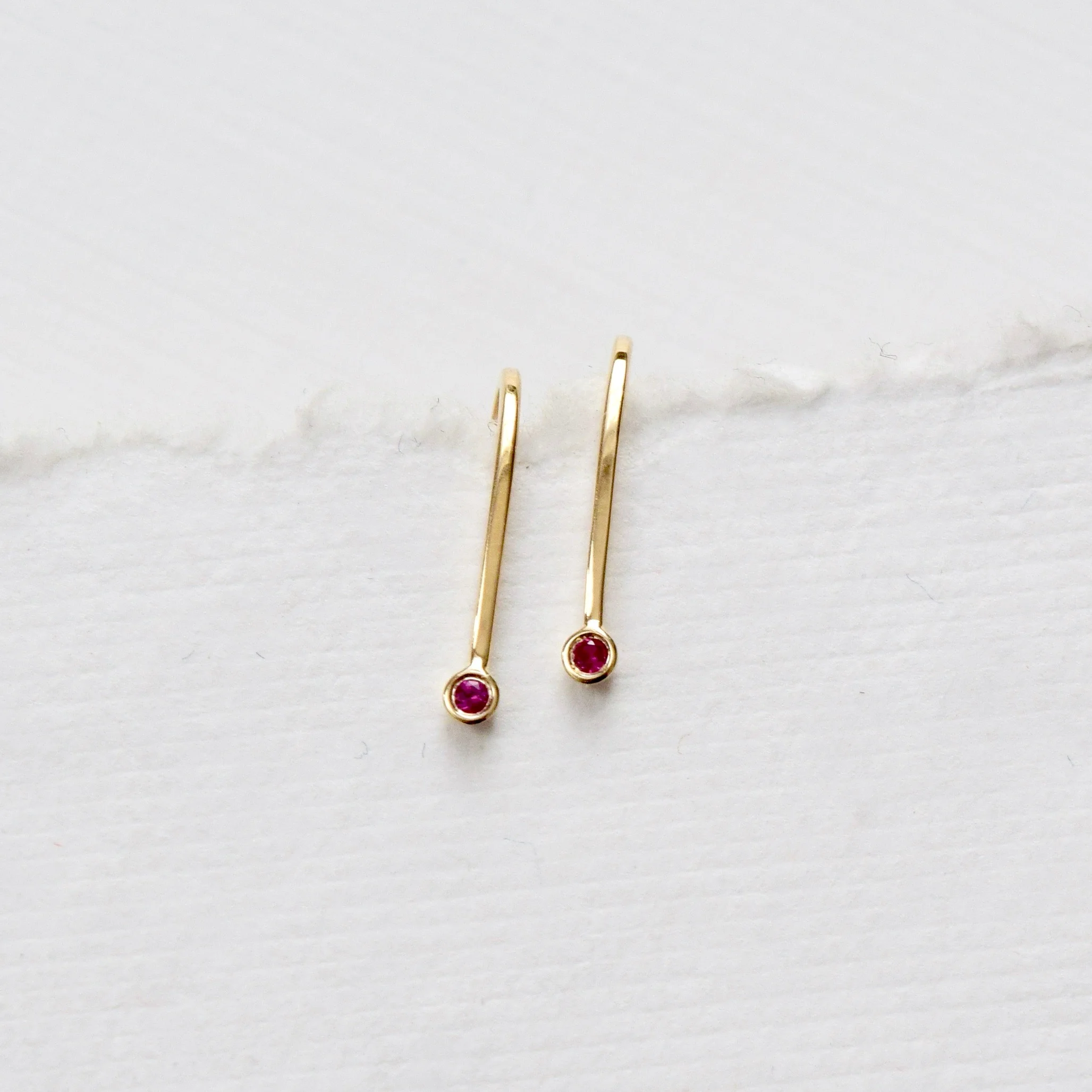 Simple gold ruby earrings, shaped like little magnets. A reminder to be the energy that we want to attract.