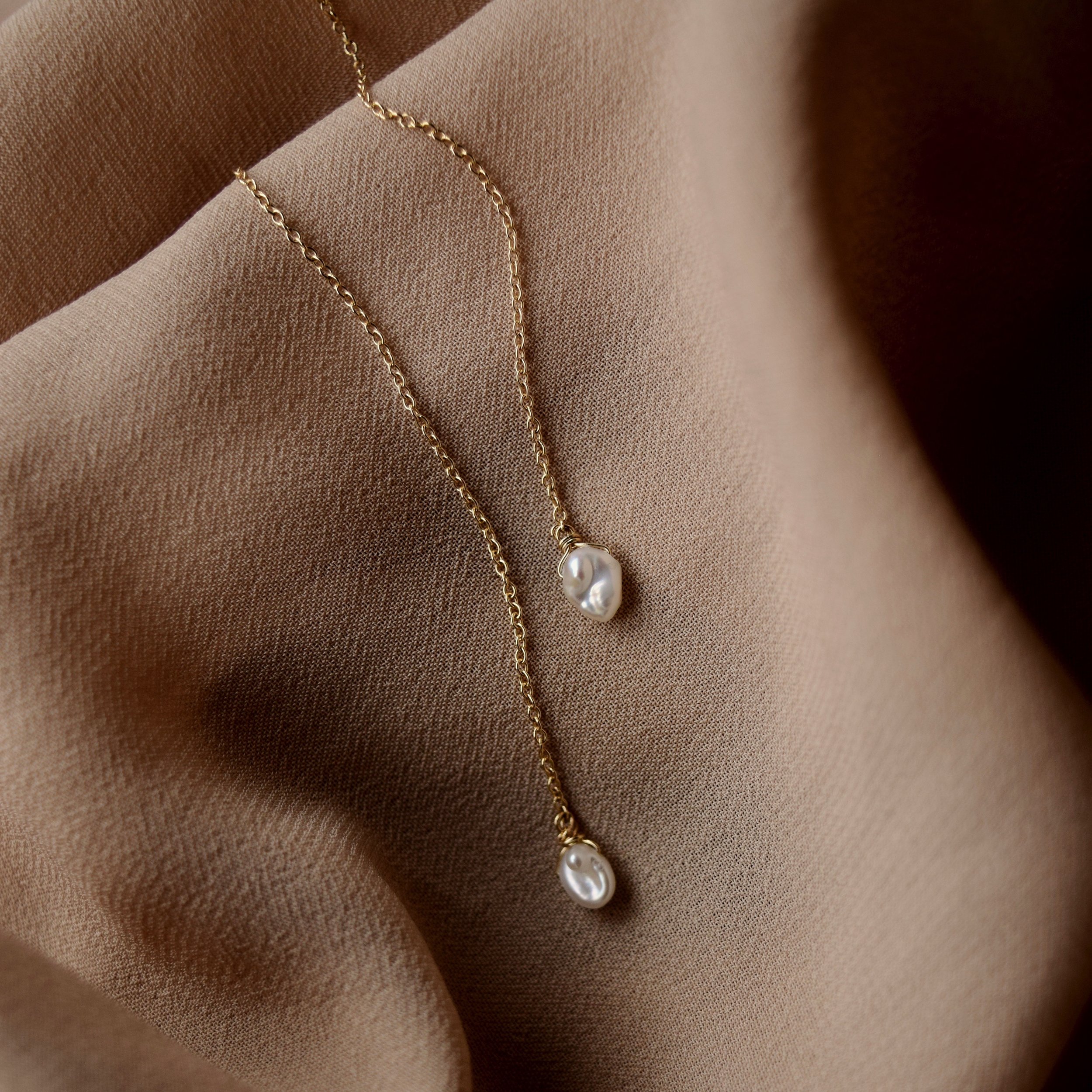 Solid 14k yellow gold threaders, adorned with beautifully imperfect natural keshi pearls. Wear it long, or thread it through multiple piercings for a delicate statement look.