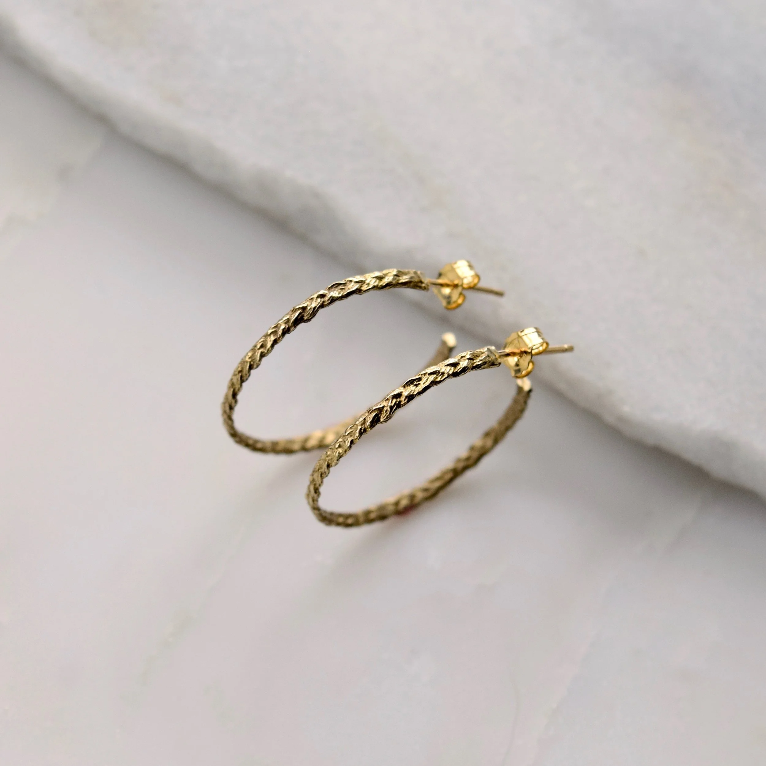 Playful braided hoops cast from woven threads, in honor of the colorful friendship bracelets you made as a kid. A fun reminder of carefree summers and time spent with your besties.