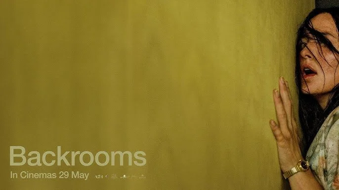 Woman pressing against a yellow wall, hair disheveled, worried look on face.