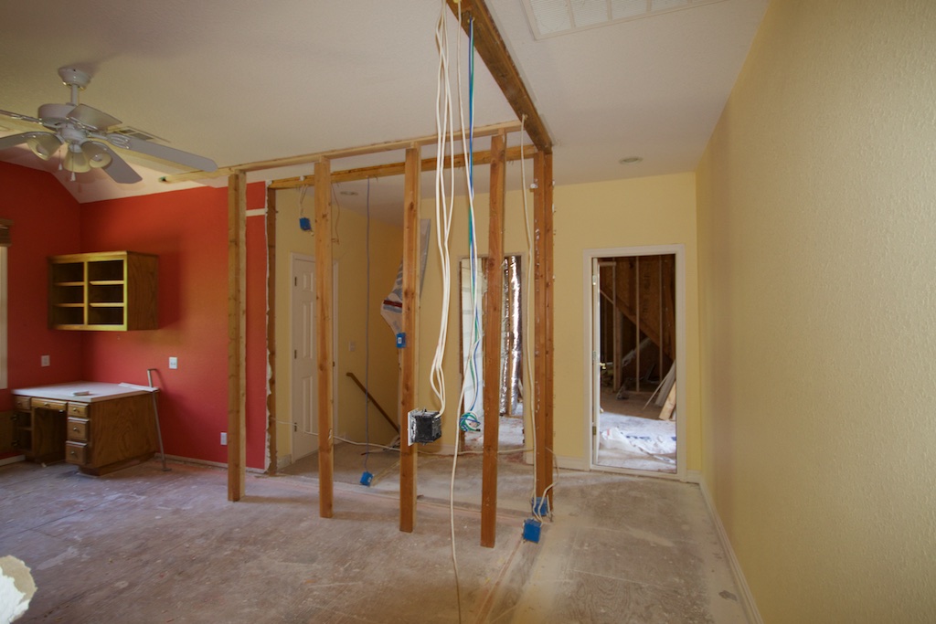 Middle of the upstairs hall, looking east. The corner walls of that 4th bedroom have been removed. The framing that is there is temporary. You can see, straight ahead, the doorway into the attic. To the left of the attic doorway, you can see a space that was the linen closet. And now you can also see the back stairway.
