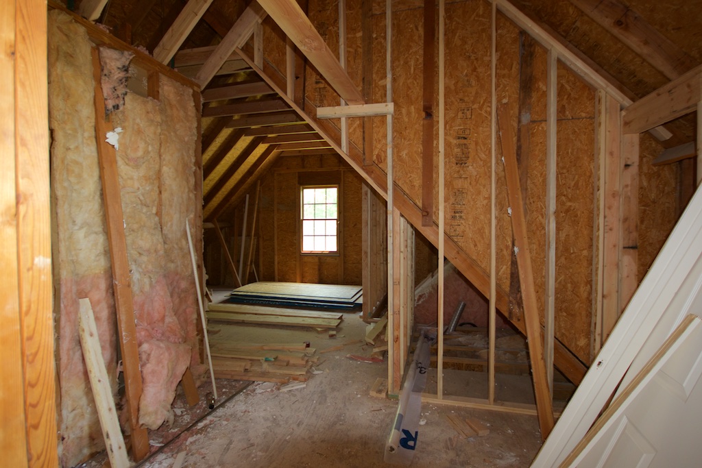Attic entry, looking east. It's difficult to see what's what here, but we're looking into the new living space/guest room area of the studio wing. They have started to frame out some walls and new storage rooms. On the left is the the insulated stairwell. The window will be replaced with a double hung. 