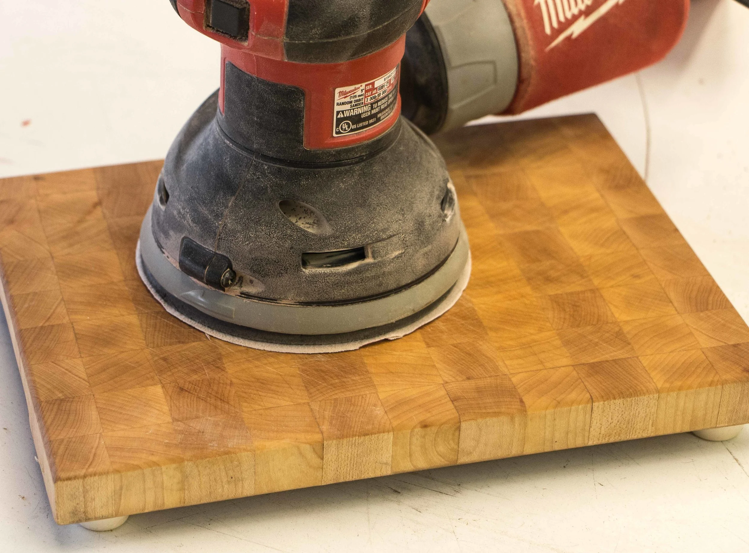 using an orbital sander with rough grit sandpaper to begin removing scratch marks