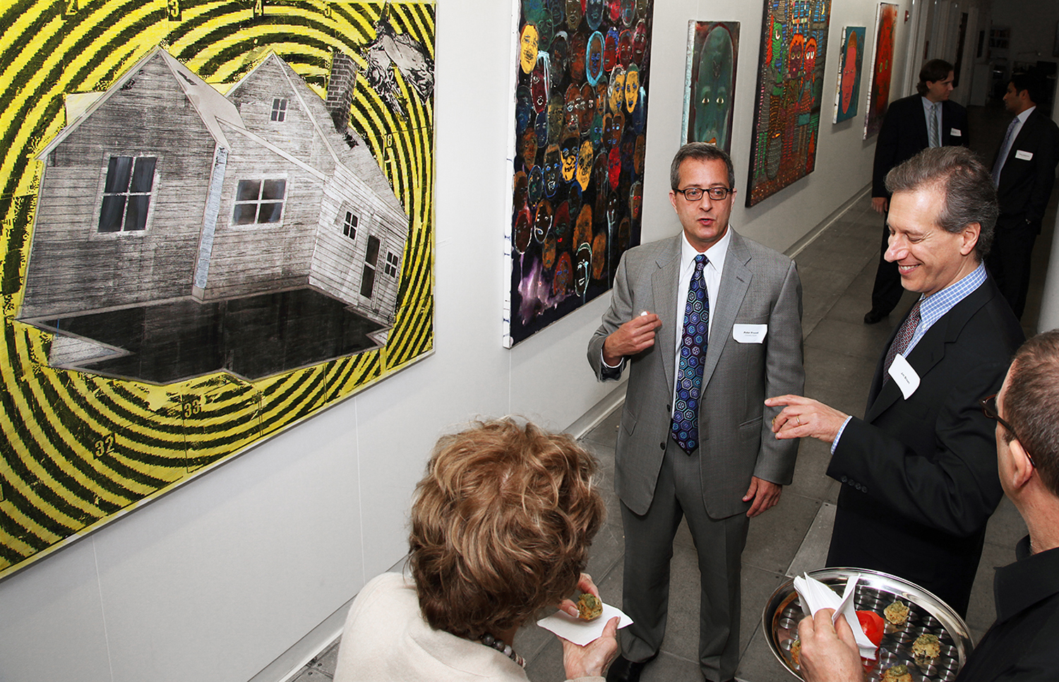 Dr. Peter Provet discussing the painting Dorothy's House with guests at the 10th anniversary exhibition.