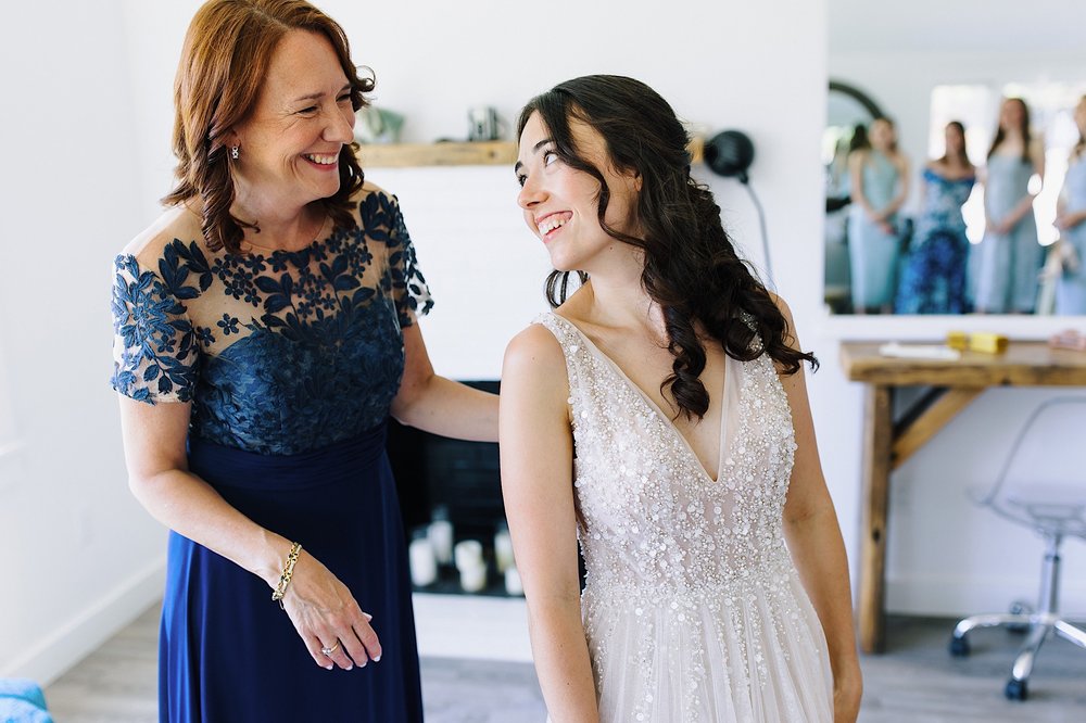 039-ZacWolfPhotography-20220625-Blog_Bride-being-helped-by-mom-into-wedding-dress.jpg