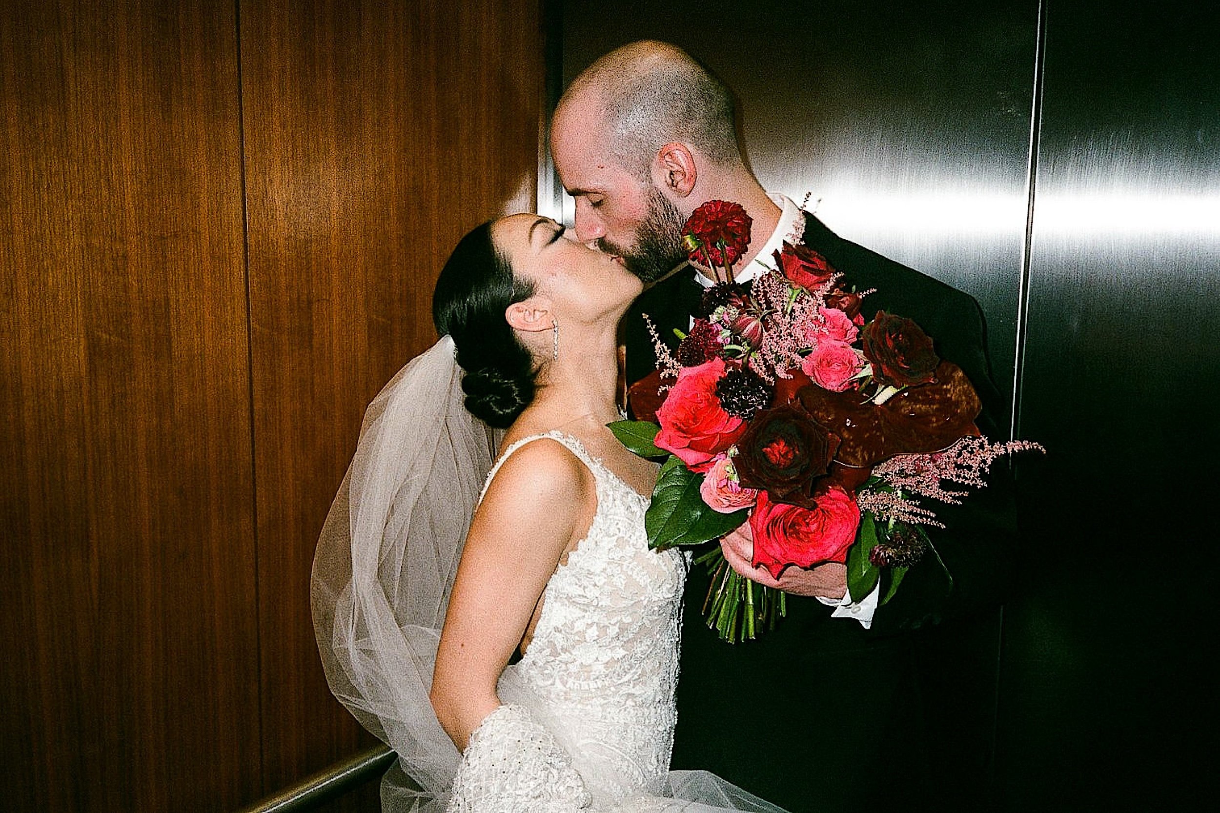 Film-ZacWolfPhoto-3-2_Candid photo of bride and groom kissing.jpg