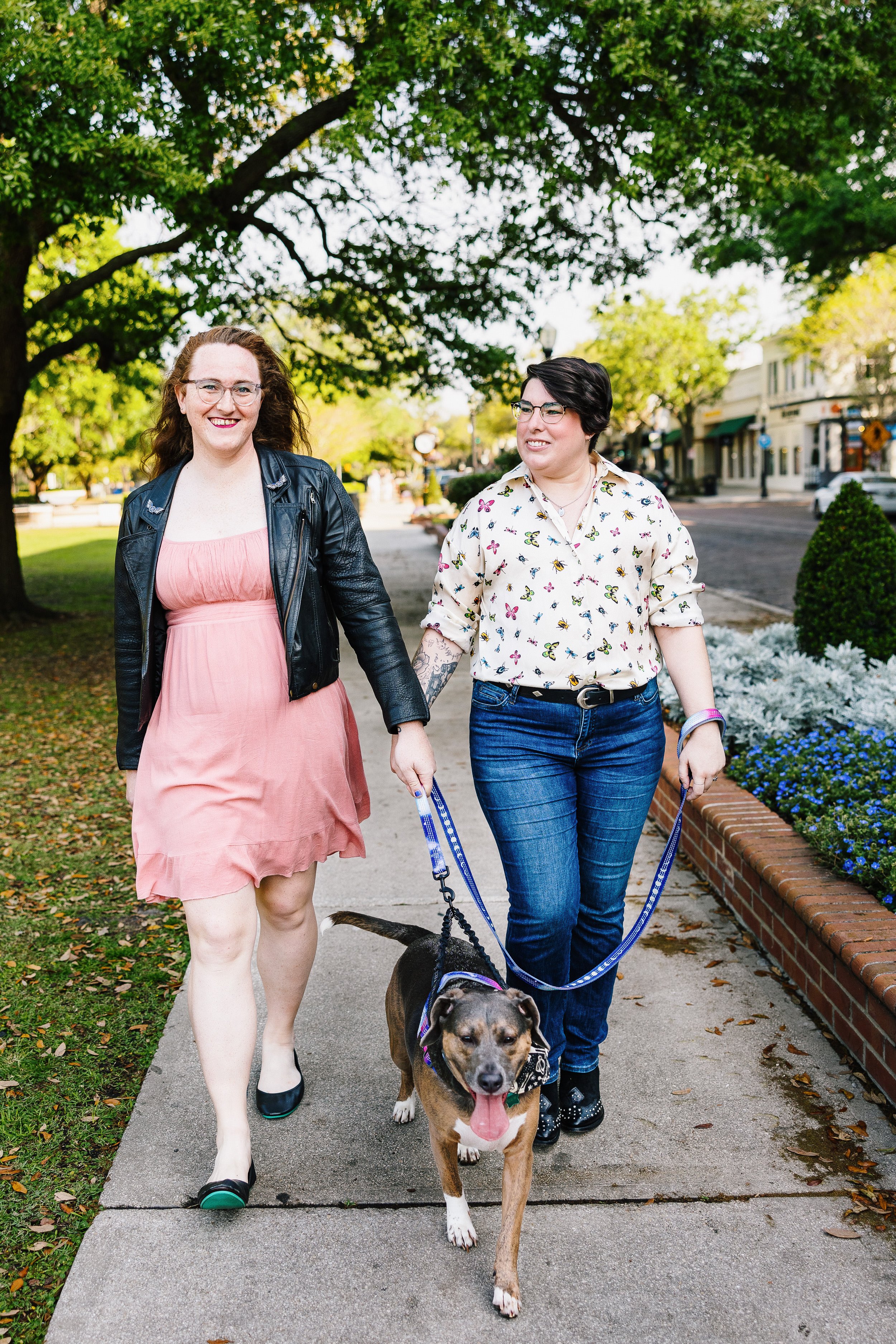 Orlando couple walking with a dog on a sidewalk.