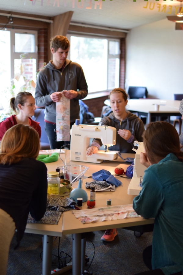Stacy teaching folks how to use sewing machines to make neck warmers