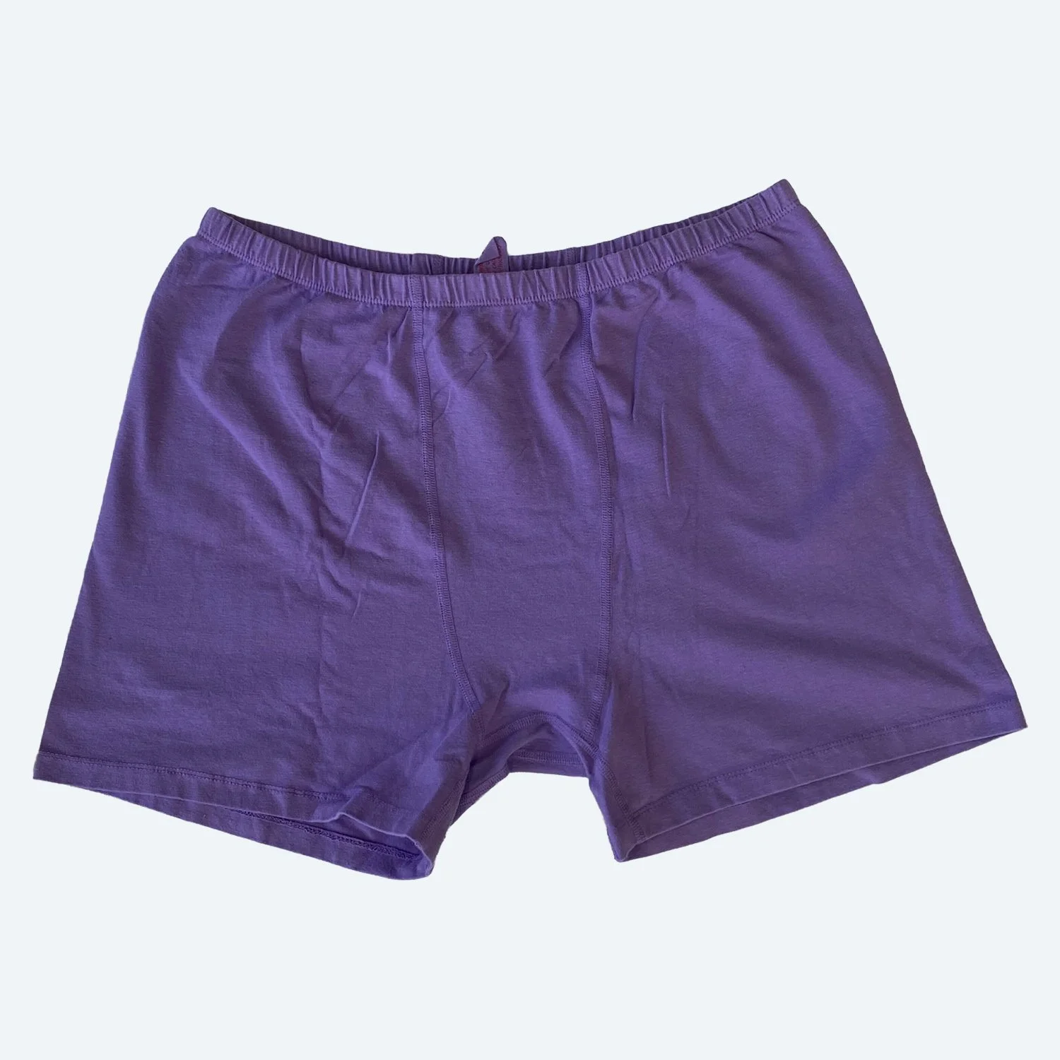 Flat lay of Pansy stretch shorts in lilac purple on a pale blue-gray background.