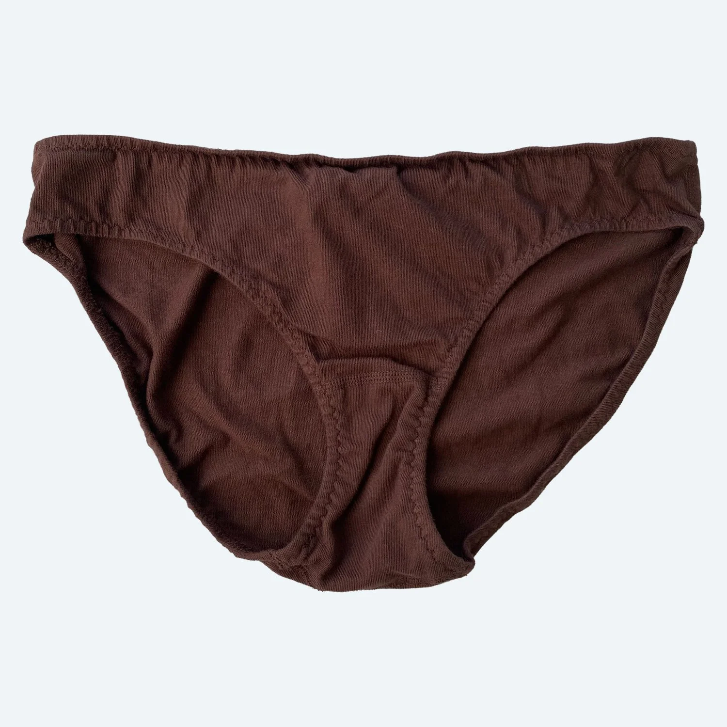 Flat lay of Pansy low rise underwear in cocoa brown on a pale blue-gray background.