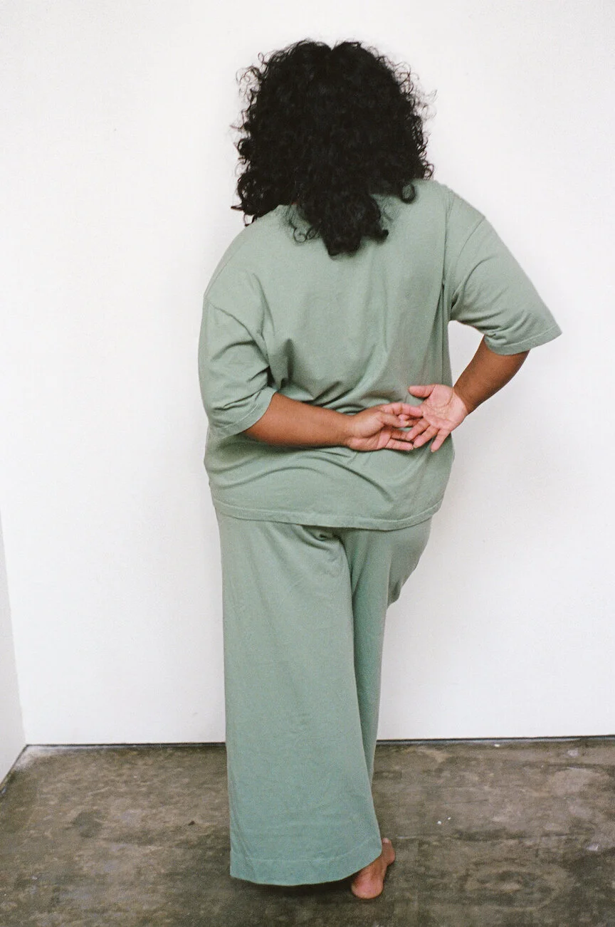 Rear view of a model wearing Pansy drawstring pants in Mermaid.