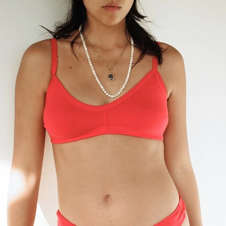 A woman wears Pansy's organic cotton Smile Bra in the color Red.