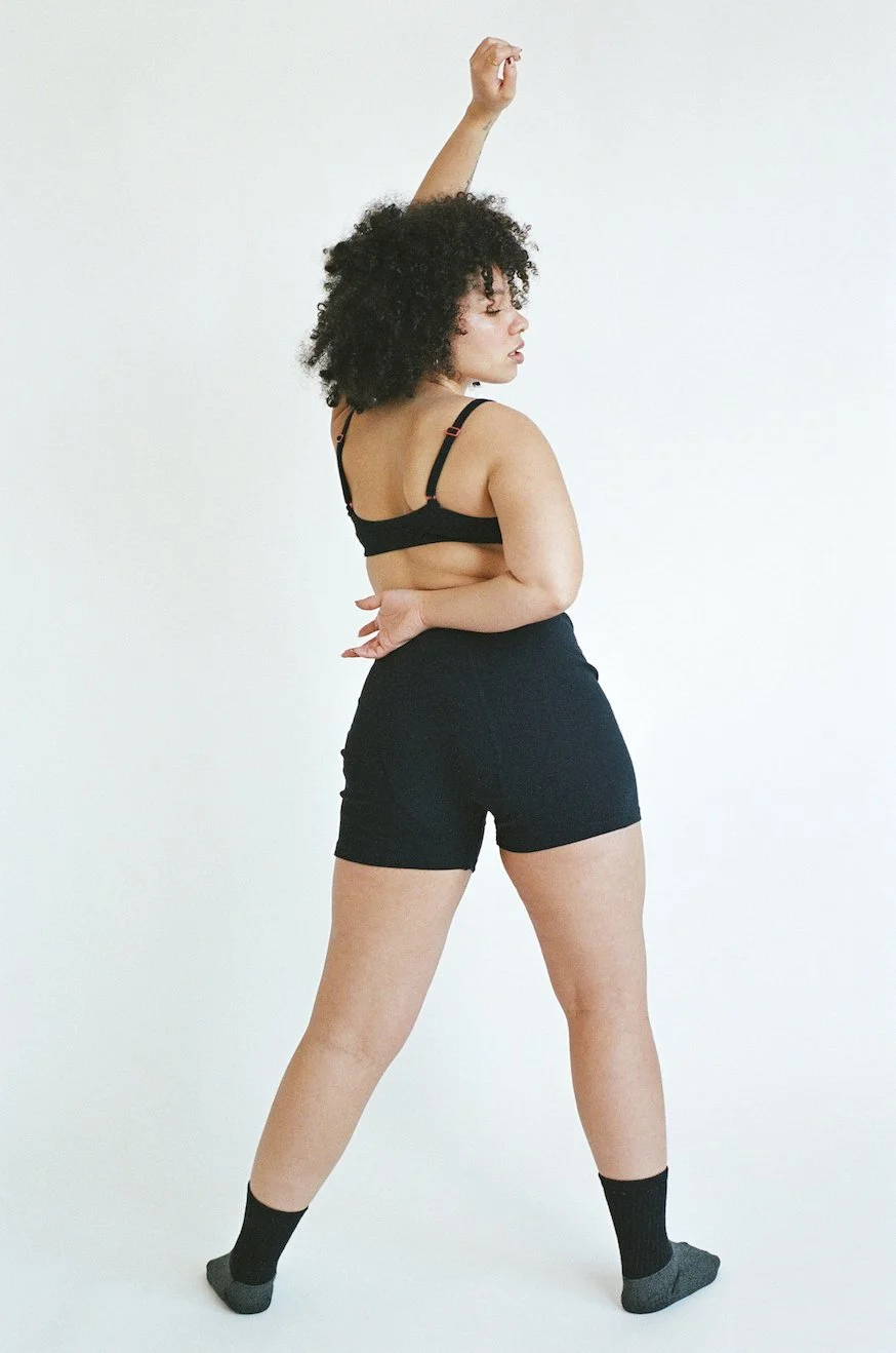 Wide shot of a model striking a dynamic pose in Pansy organic cotton Stretch Shorts.