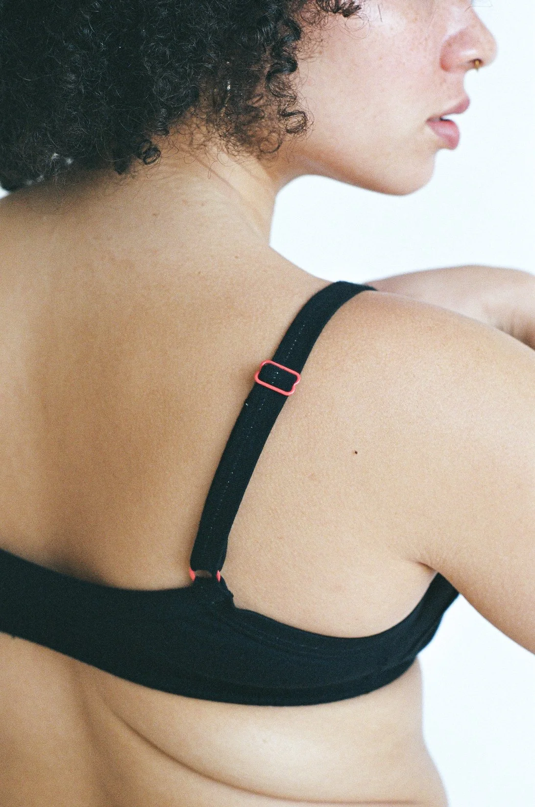 Close-up view of the bra strap adjustment hardware on a black Pansy Smile Bra.